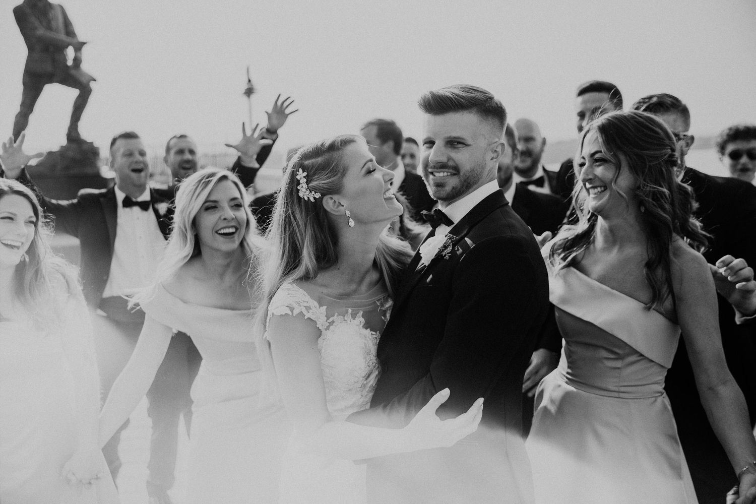 Wedding guests laugh and celebrate during an outdoor reception.