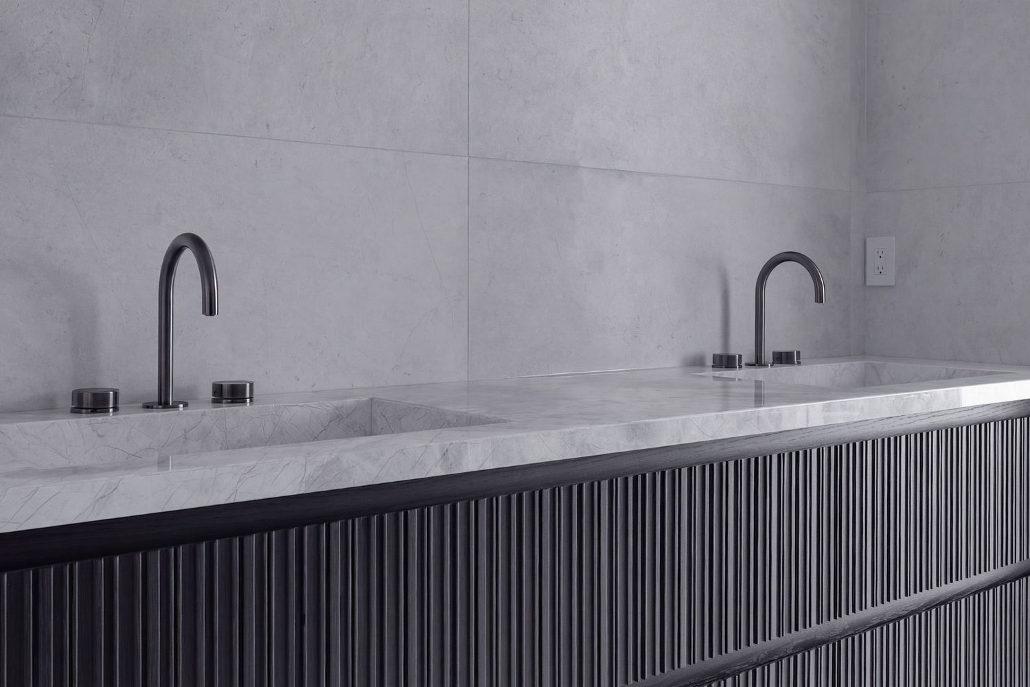 Double vanity with white marble countertop, dual matte black faucets, and dark fluted cabinet base in modern bathroom.