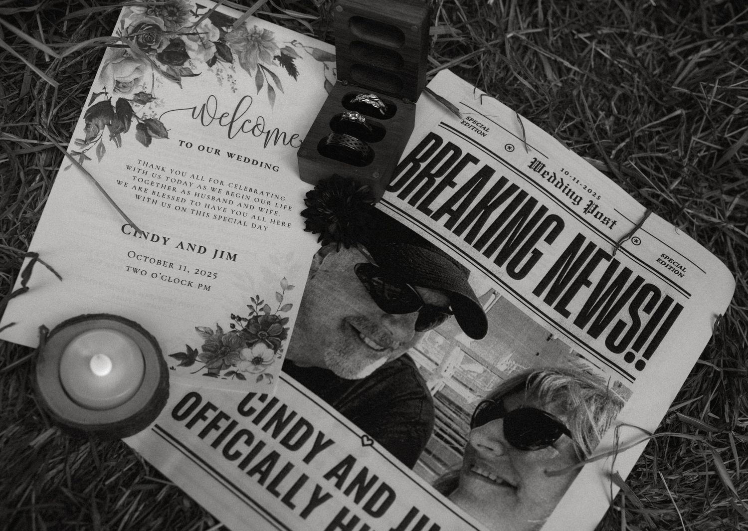 Black and white flat lay of wedding welcome card and Breaking News newspaper announcement for bride and groom with candle.