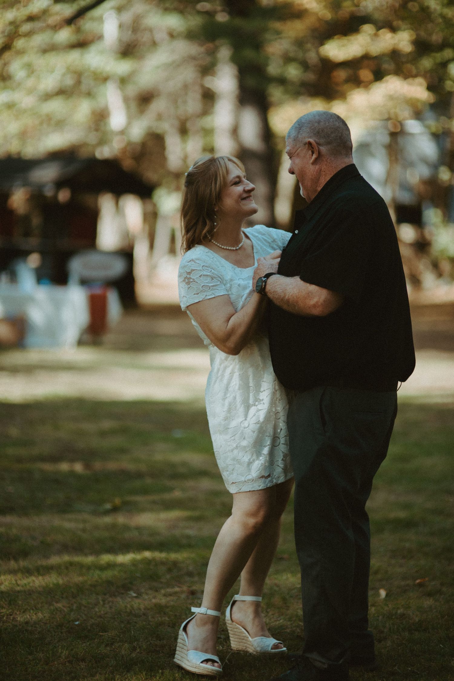 Newlyweds dancing outdoors among trees