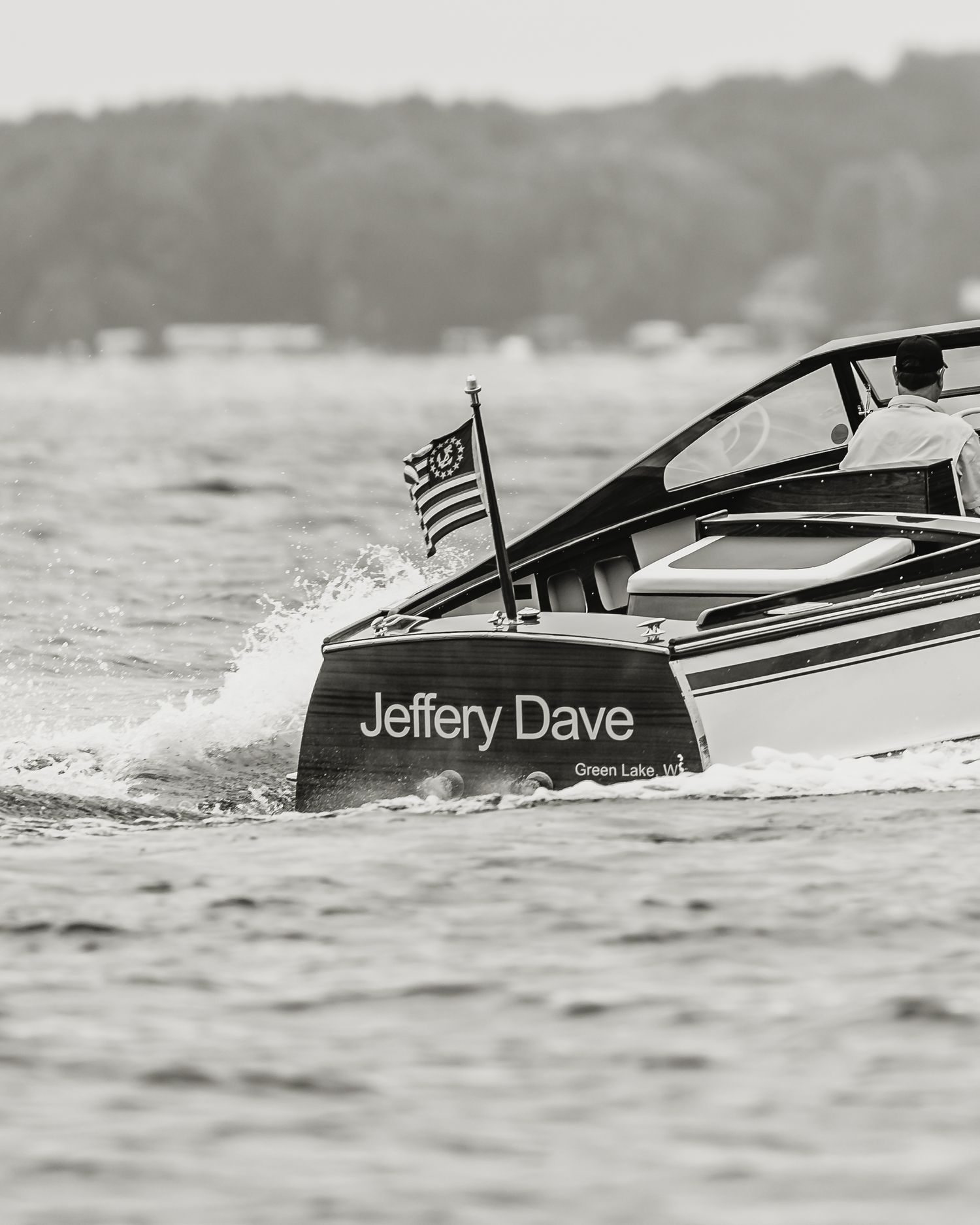 Black and white photo of a classic wooden boat named Jeffery Dave from Green Lake WI speeding across water.