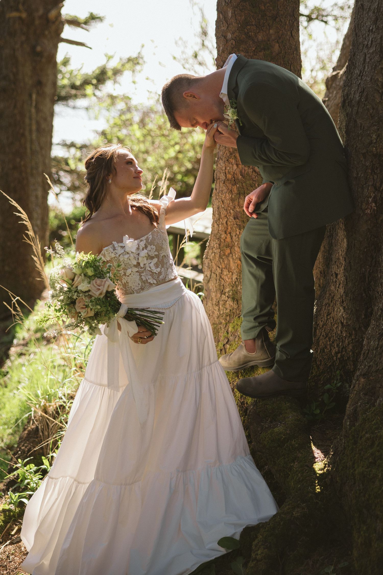 Wedding couple sharing intimate moment among pine trees in natural setting.