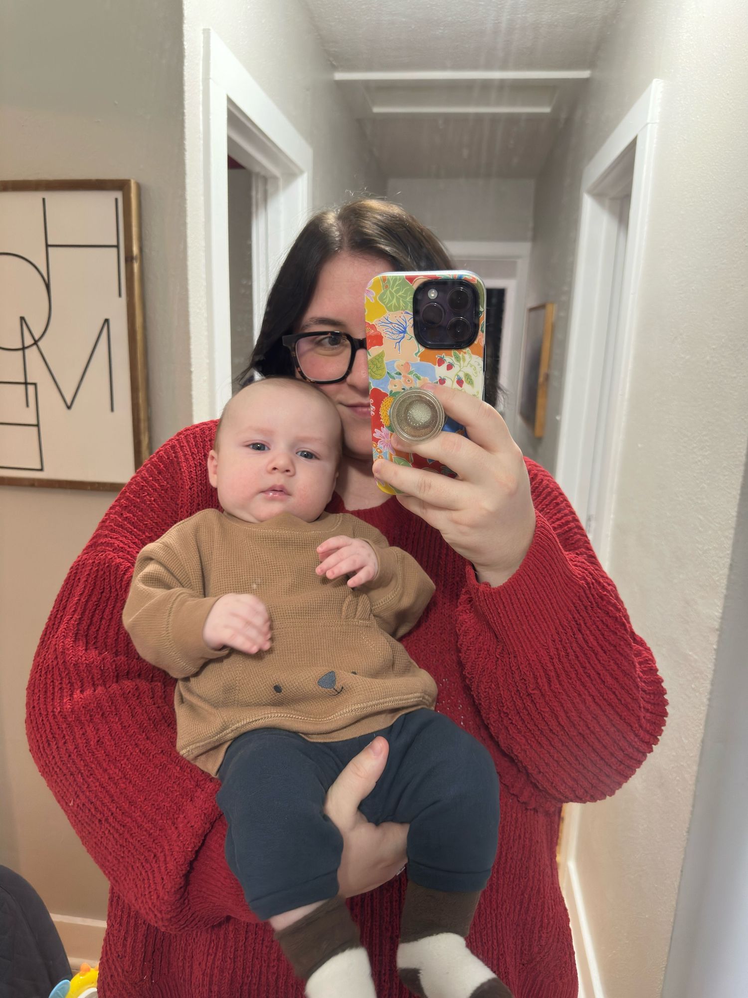 Series of selfies in a hallway with someone wearing a red sweater holding a baby.
