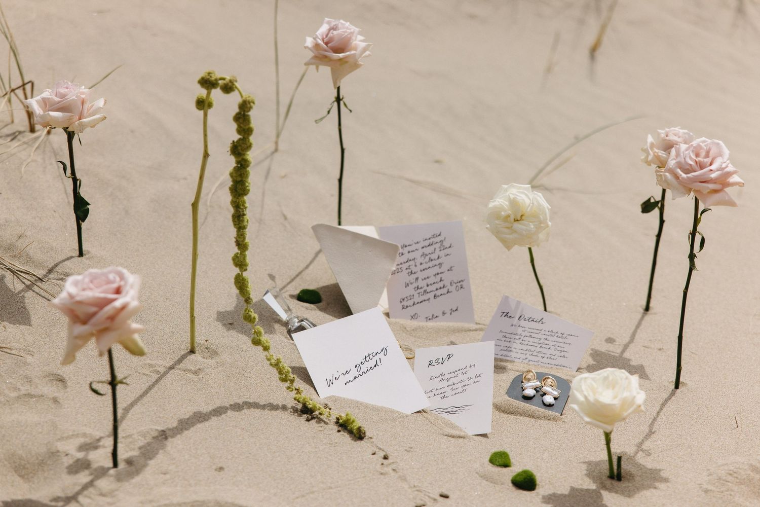 Delicate pink roses and handwritten notes arranged as wedding decor.