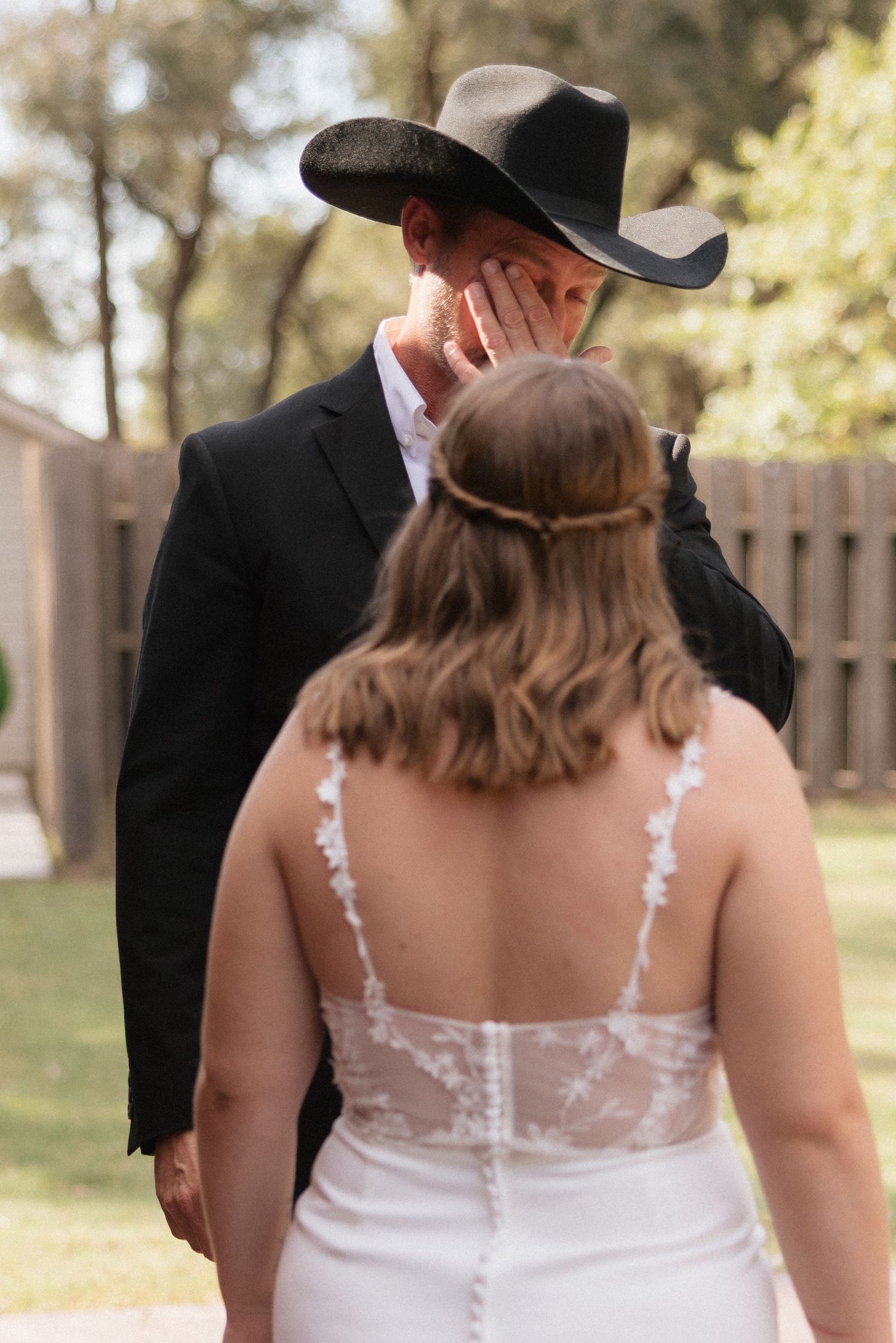 Bride in a delicate lace wedding dress with sheer back details walking outdoors.