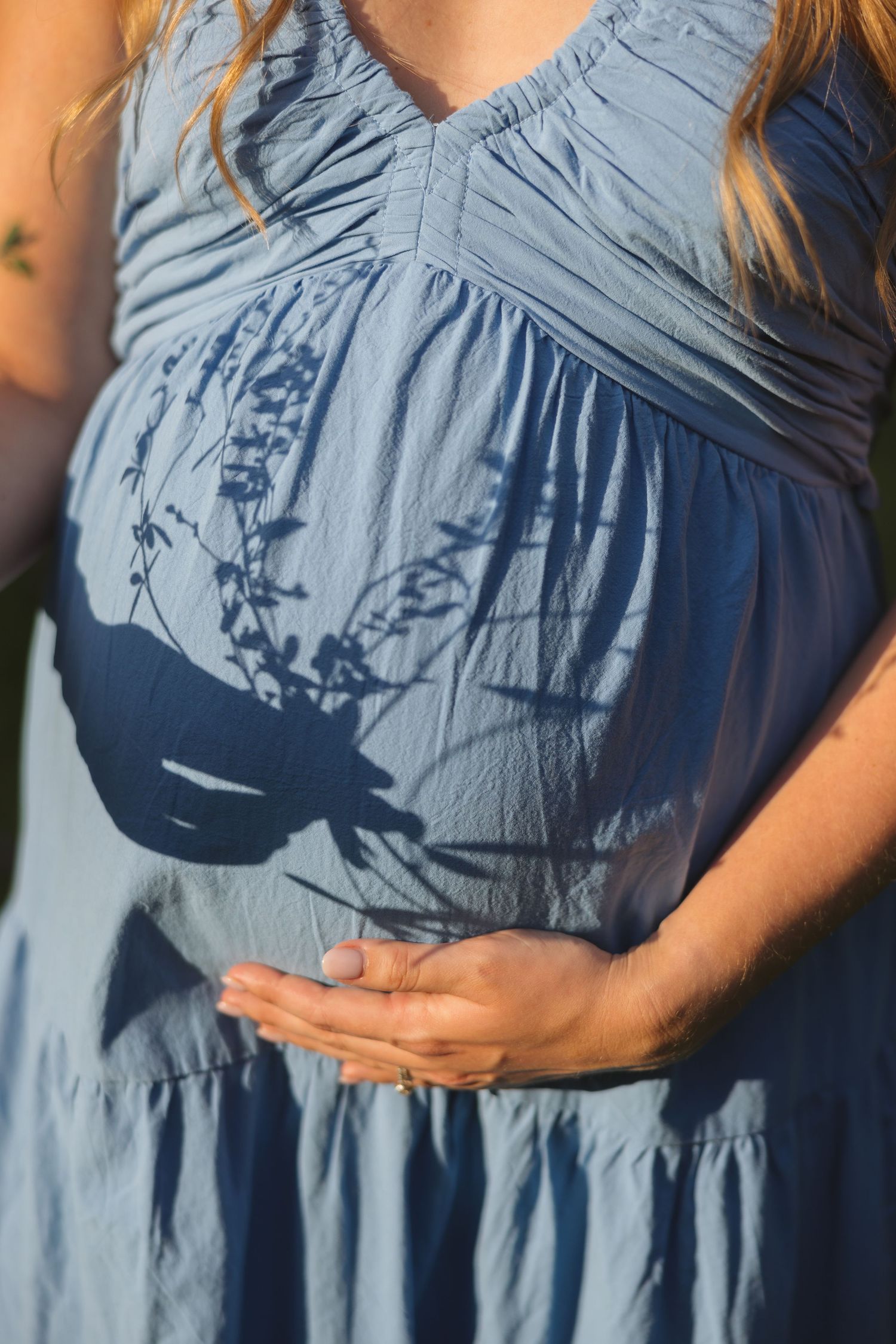 Close-up photos of a light blue maternity dress showing the belly details.