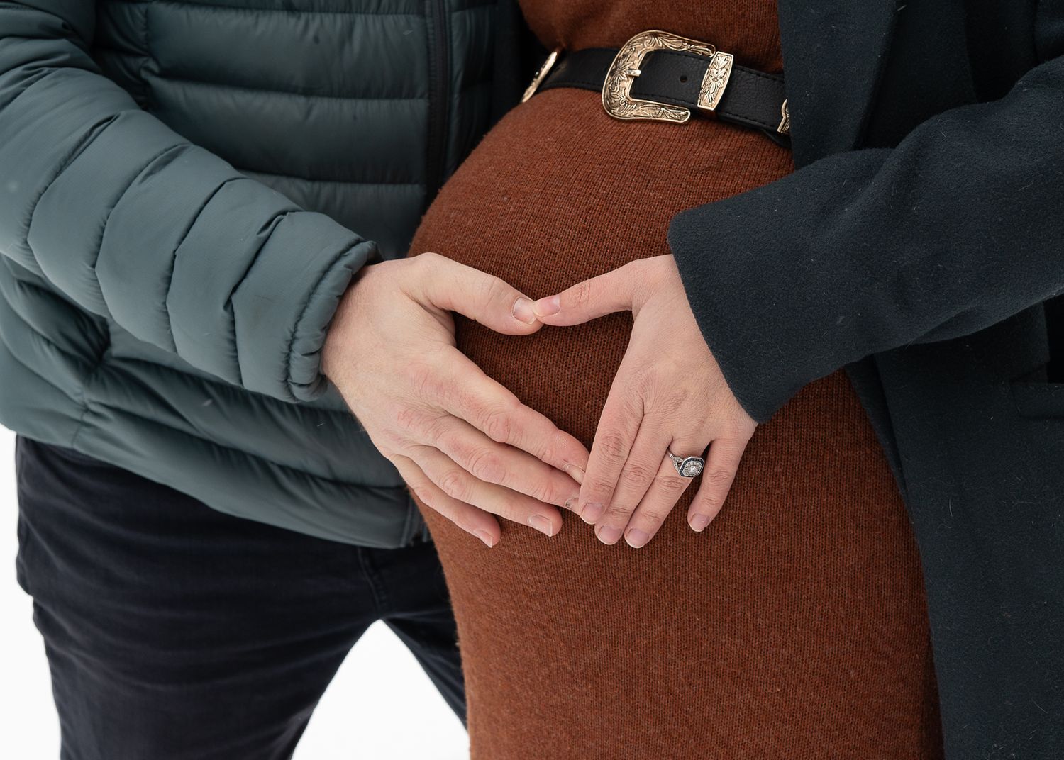 Couple posant les mains sur un ventre de grossesse lors d’une séance maternité en Estrie