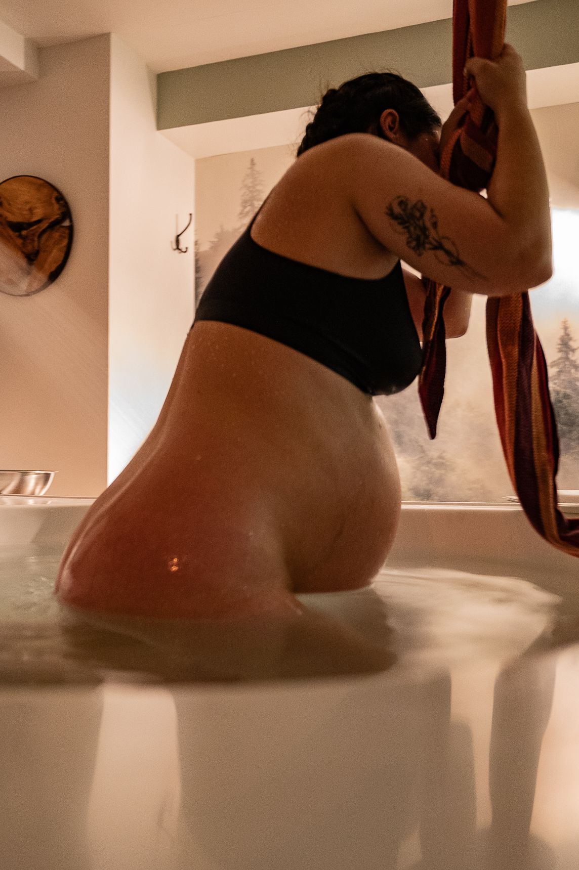 Femme enceinte dans un bain lors d’un moment d’enfantement en Estrie