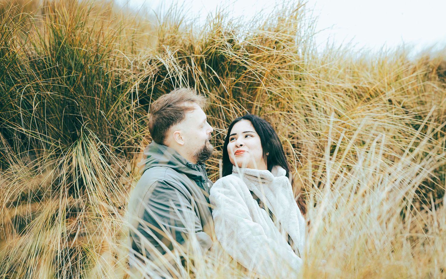Couple se regardant dans les herbes dorées – Photographe couple engagement Côte d'Opale – Thomas Denaveaut Calais