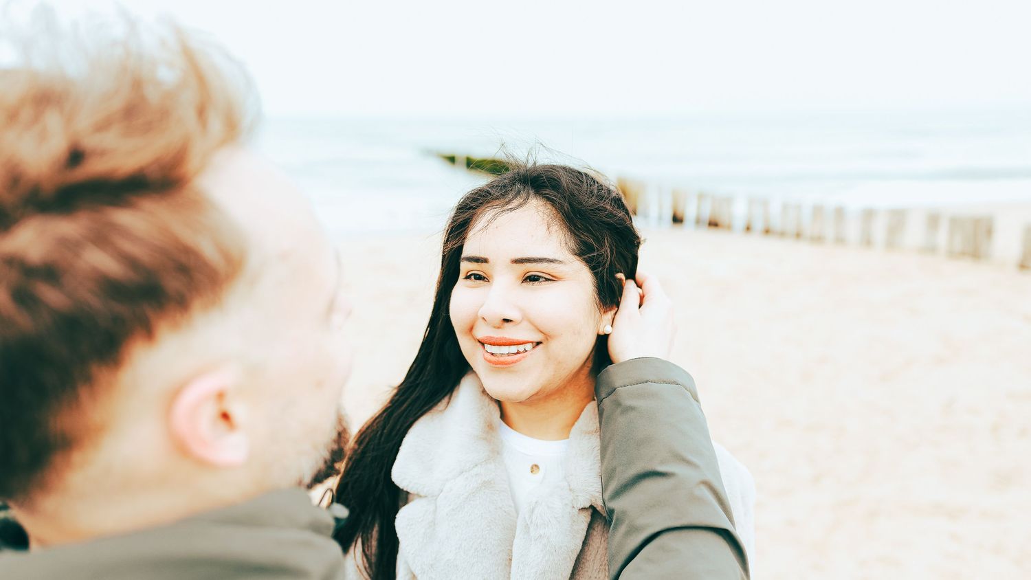 Couple souriant sur la plage de la Côte d'Opale – Séance engagement naturelle – Thomas Denaveaut photographe couple Calais