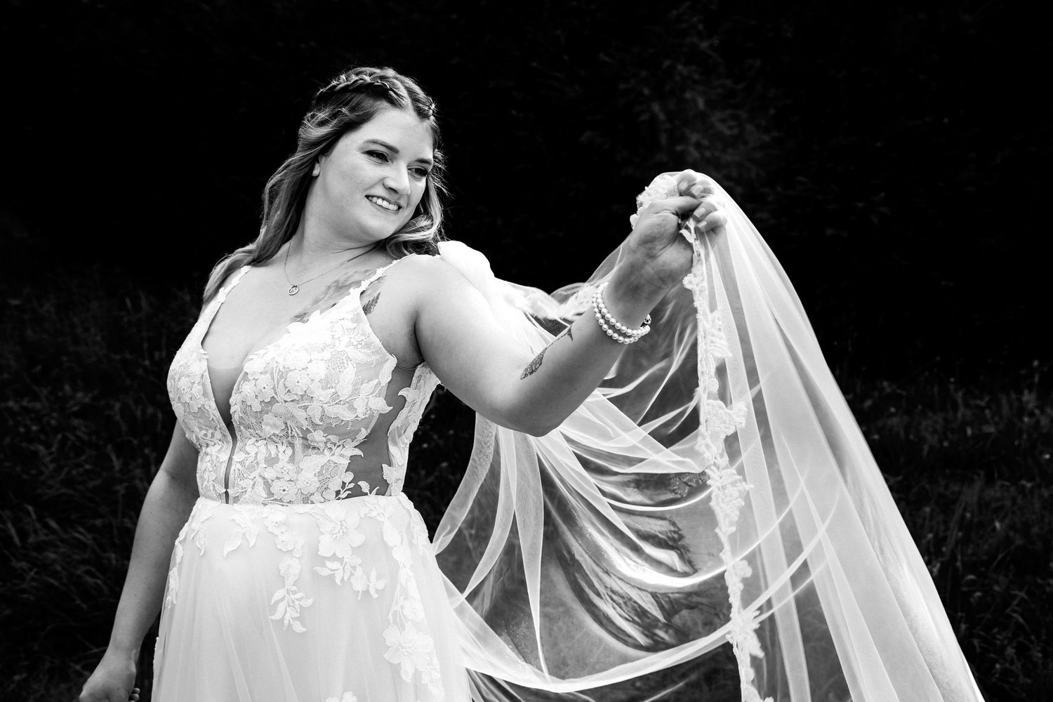 Braut im Brautkleid auf schwarzem Hintergrund.