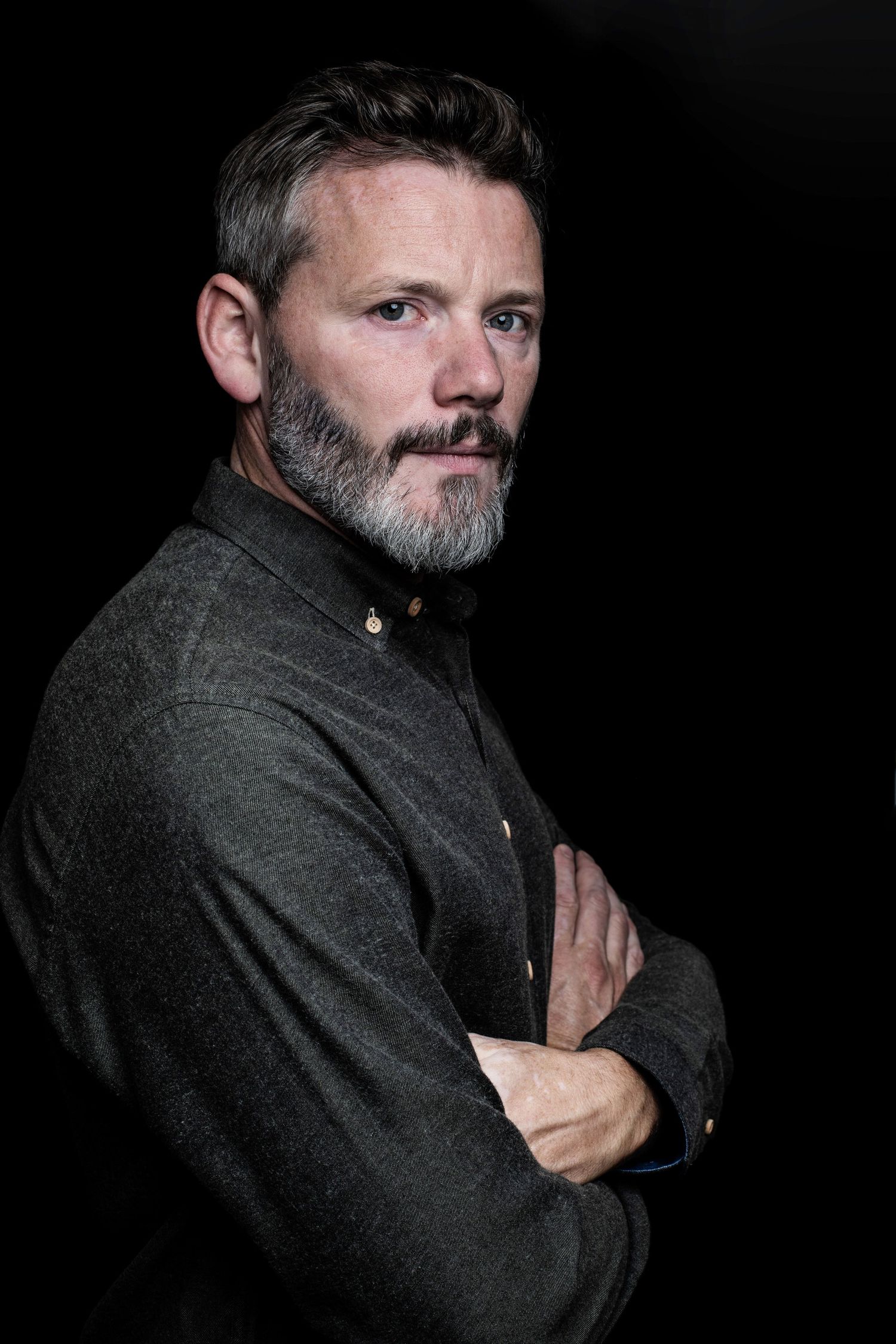 Männer Portrait vor schwarzem Hintergrund im Studio.