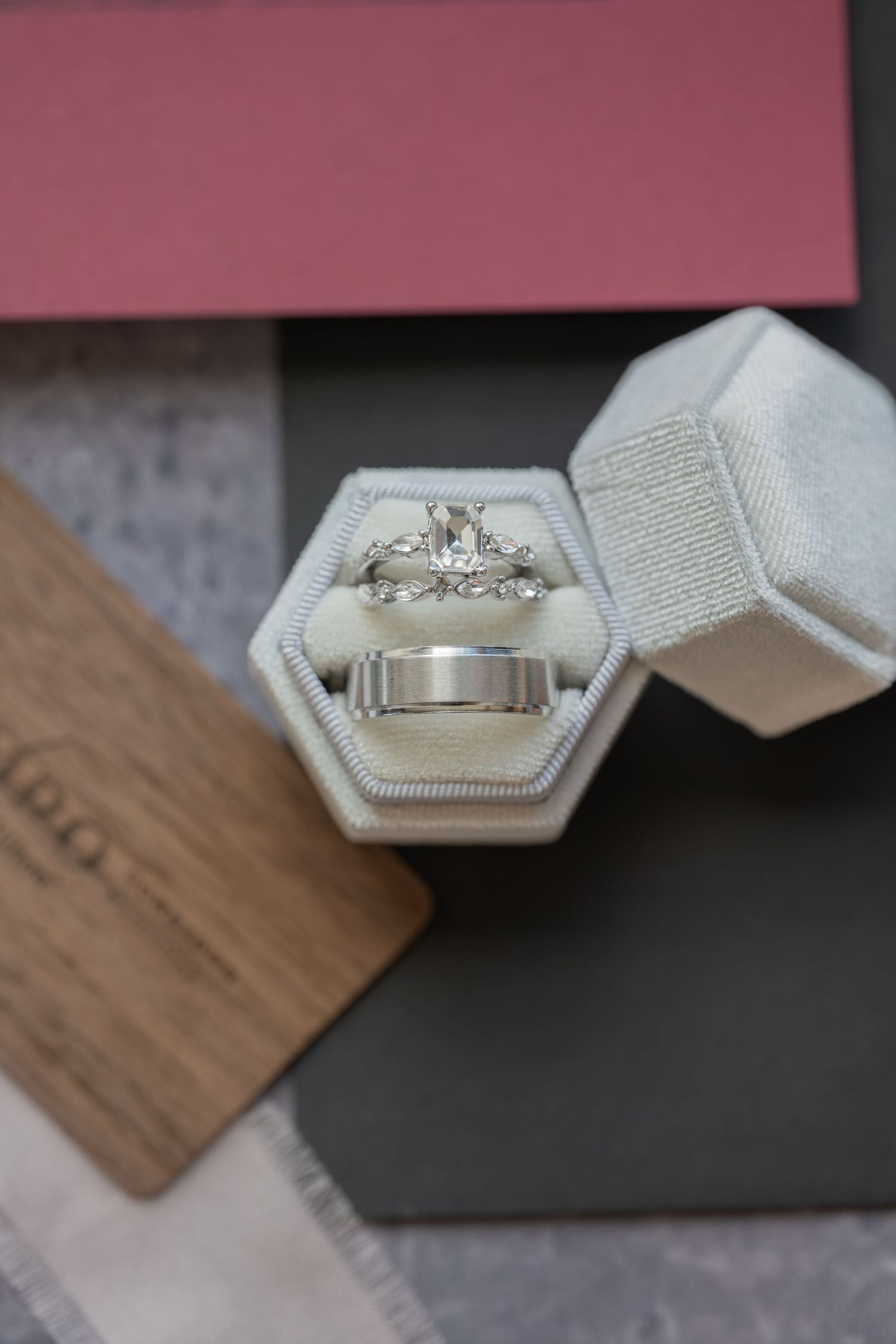 Silver engagement ring with diamond and matching wedding band displayed in a hexagonal velvet ring box.