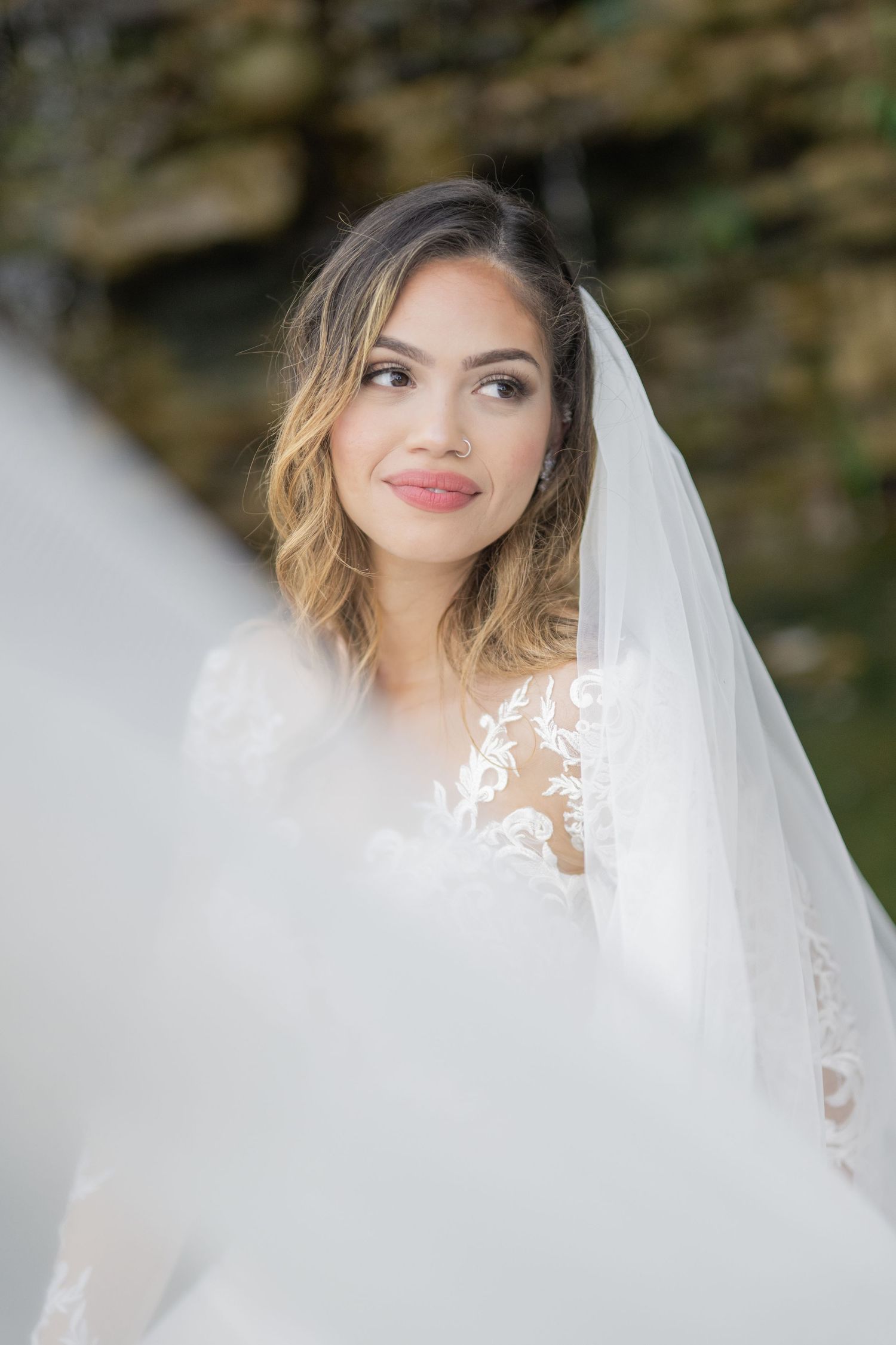 Cheekwood. Nashville. Bride in lace wedding dress and white veil gazes upward outdoors, with soft bokeh background.