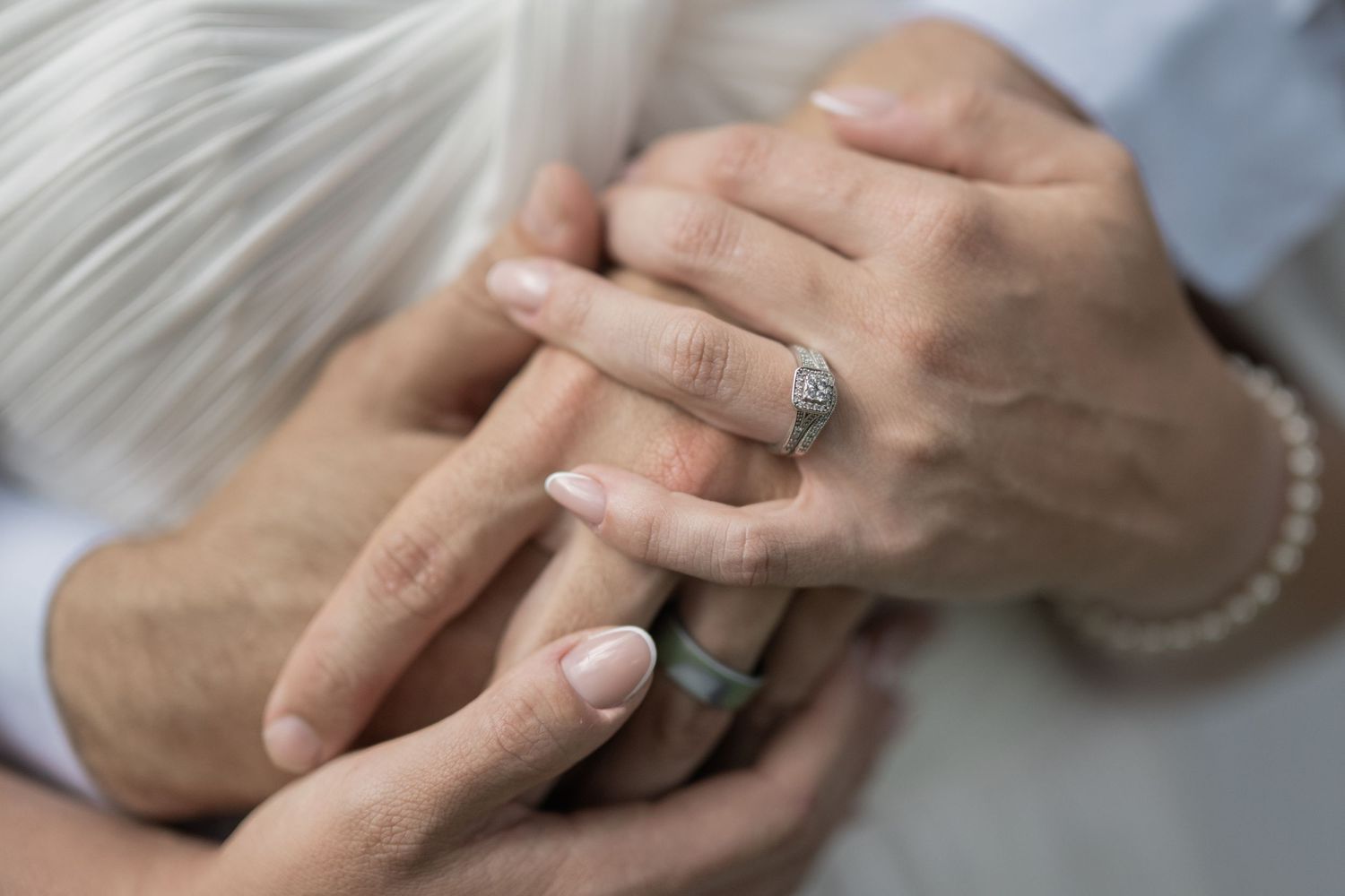 Cheekwood. Nashville. Close-up of two people holding hands, showing an elegant diamond engagement ring and pearl bracelet.