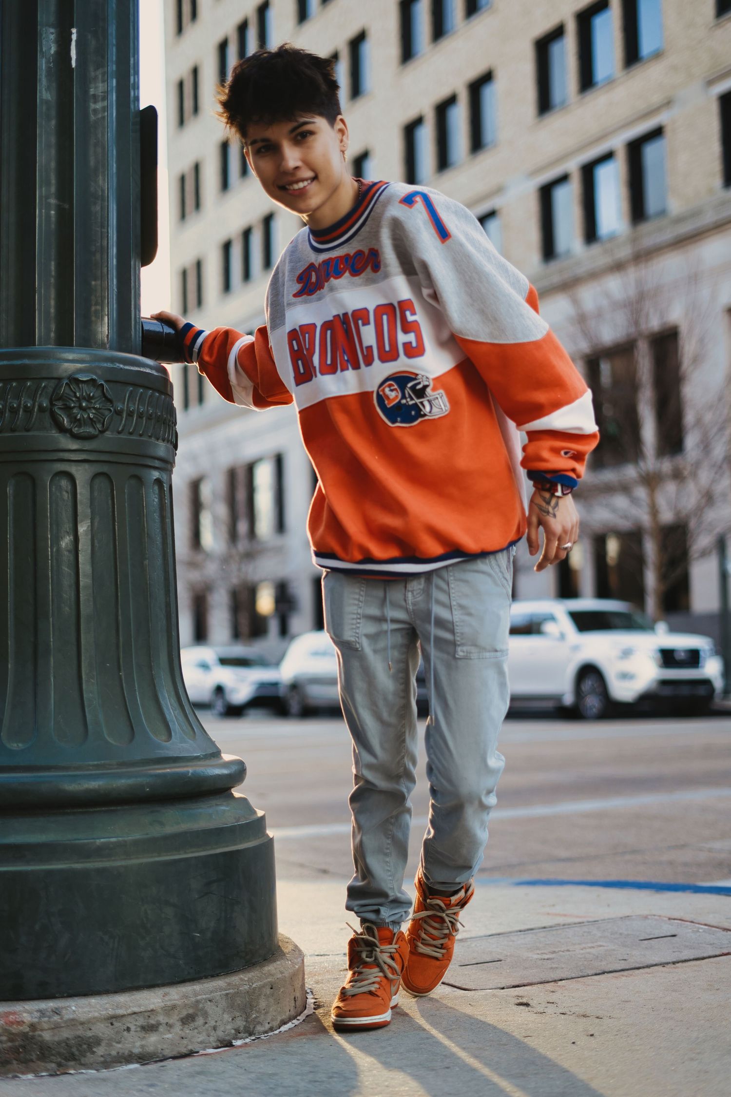 Close-up shots of orange sports jersey and sneakers on urban sidewalk.
