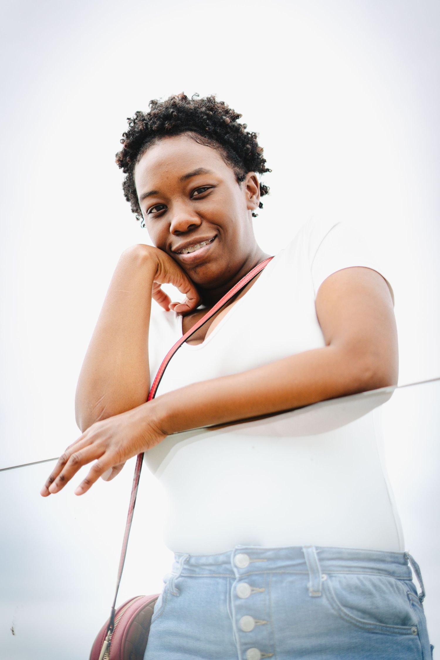 Low angle portrait against white background showing casual summer style.