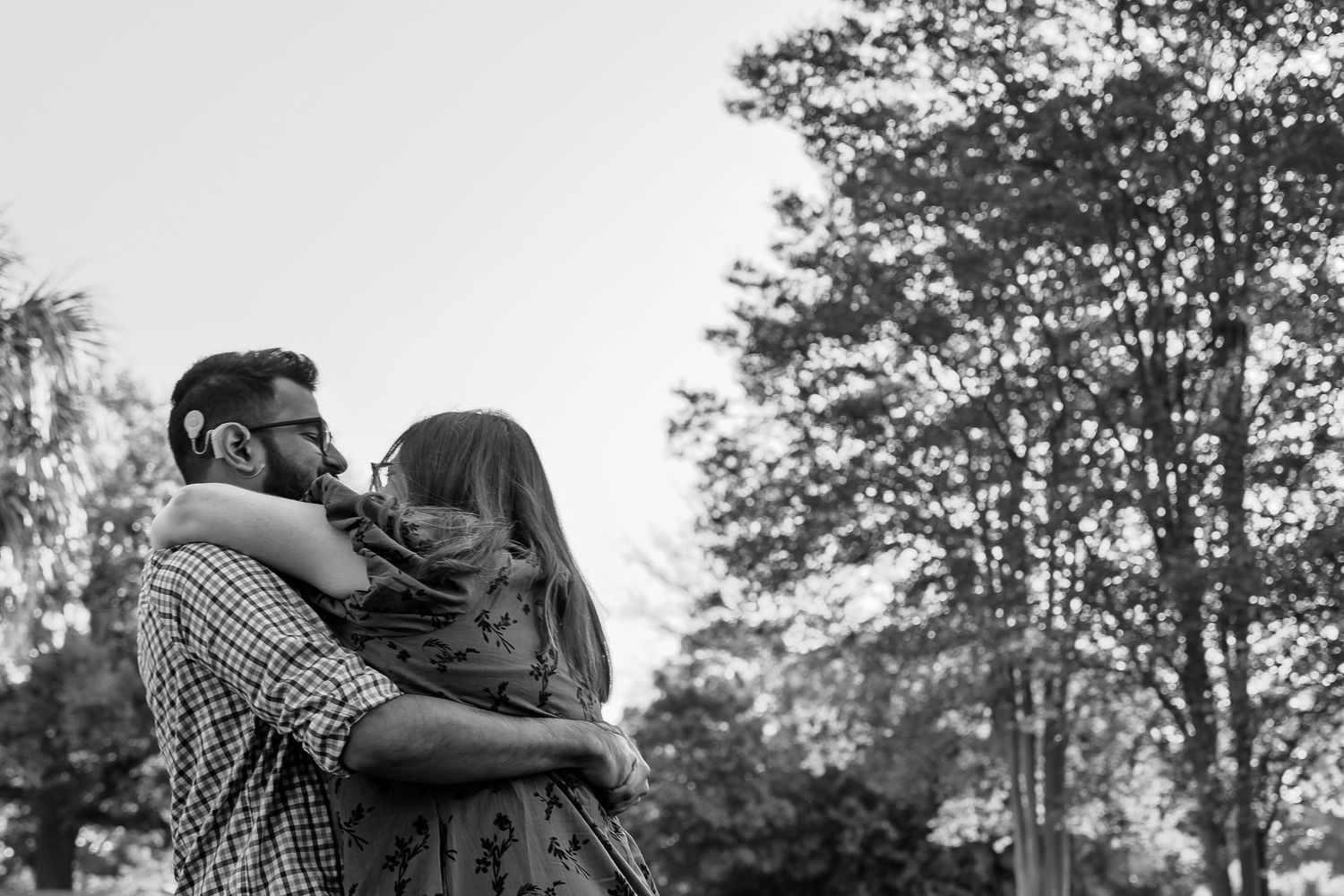Black and white romantic outdoor photo sequence with trees in background.
