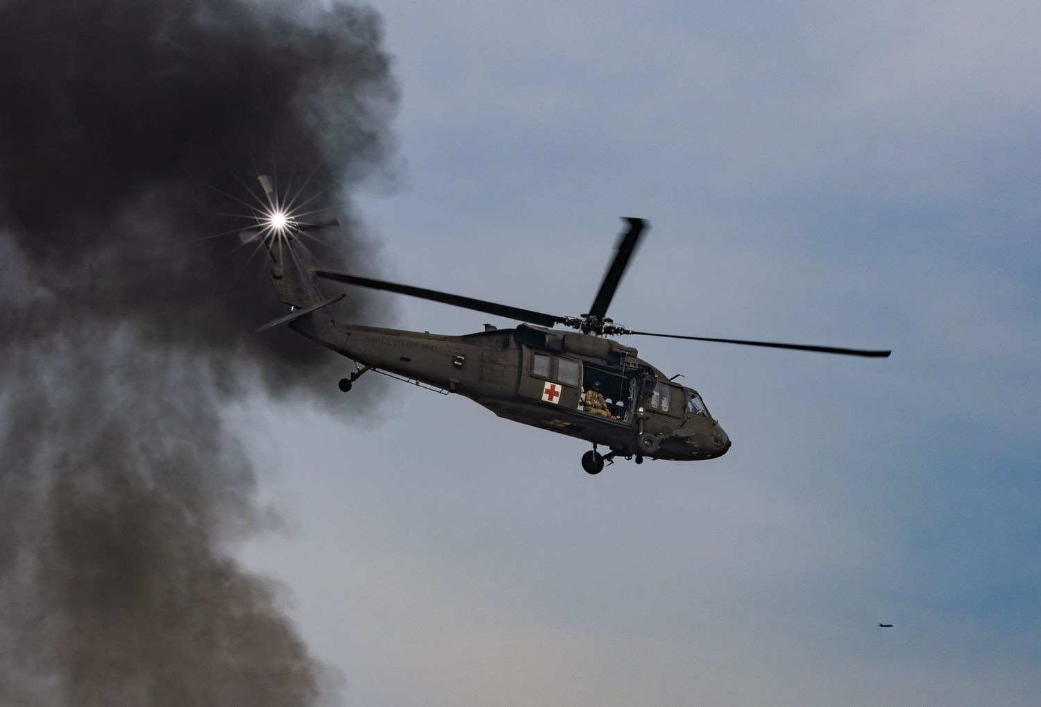 Blackhawk helicopter flying in front of black smoke