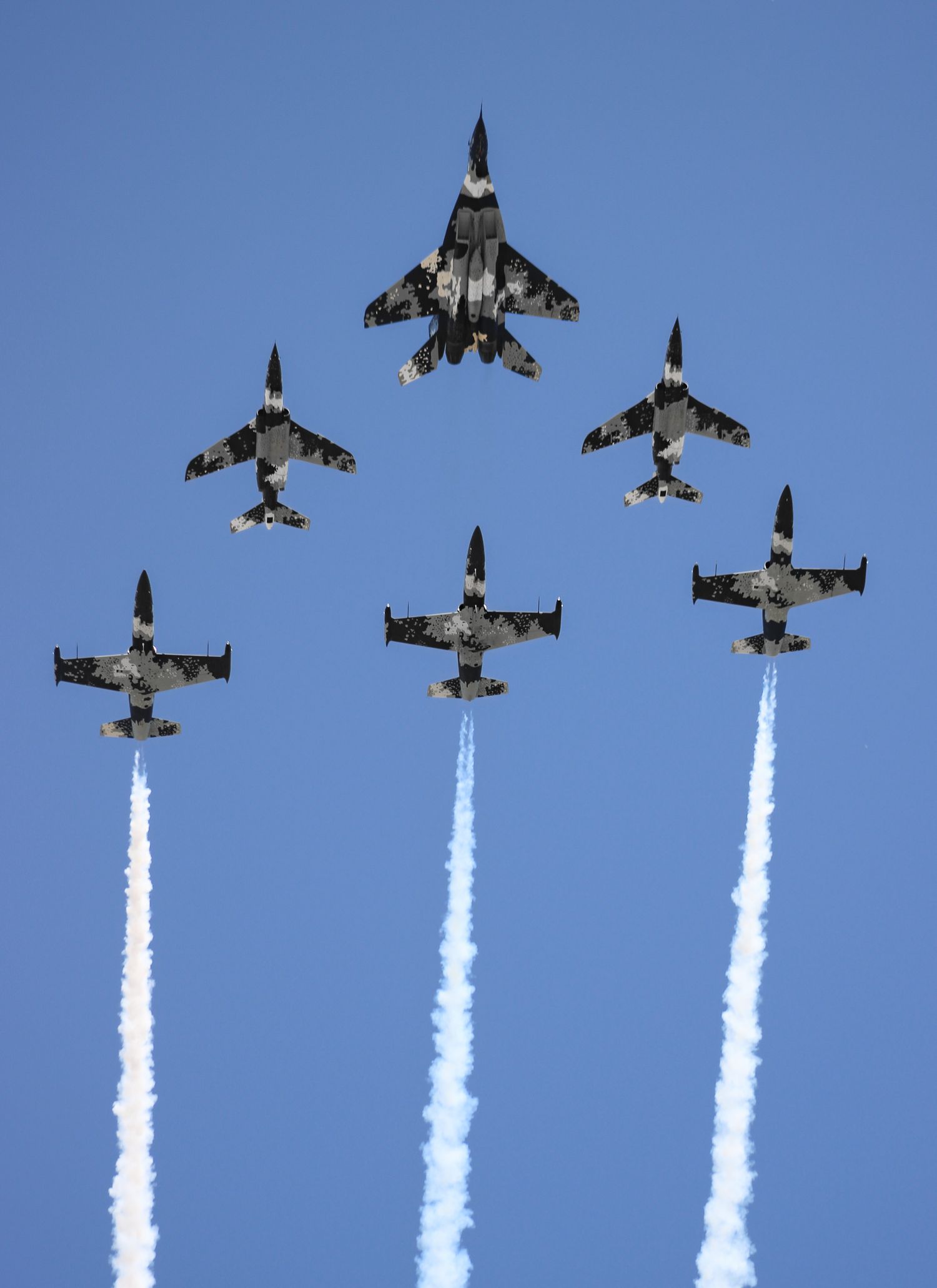Six Ghost Squadron fighters flying in formation with white smoke trails