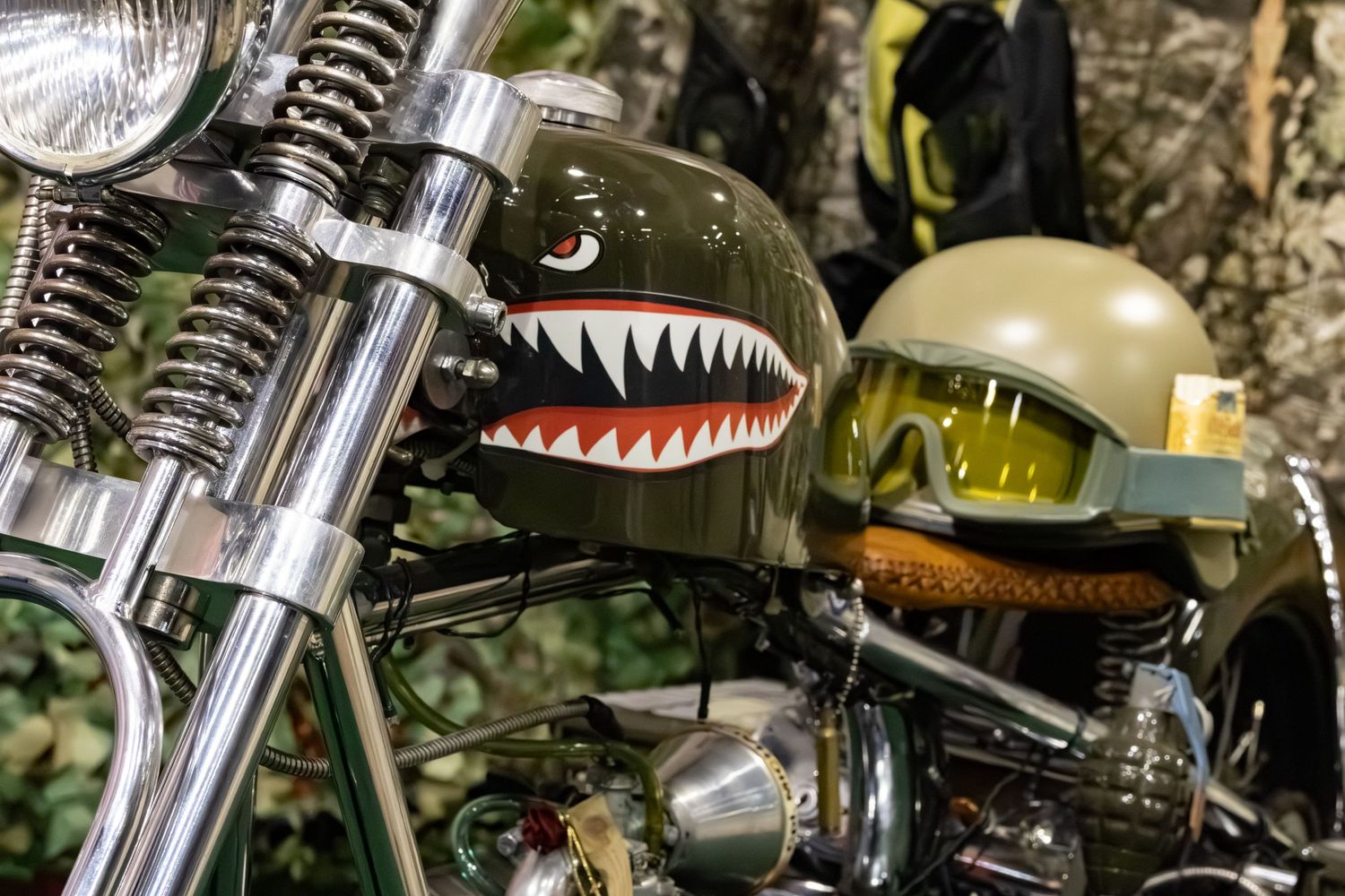 Motorcycle with Shark mouth decal and combat helmet sitting on seat