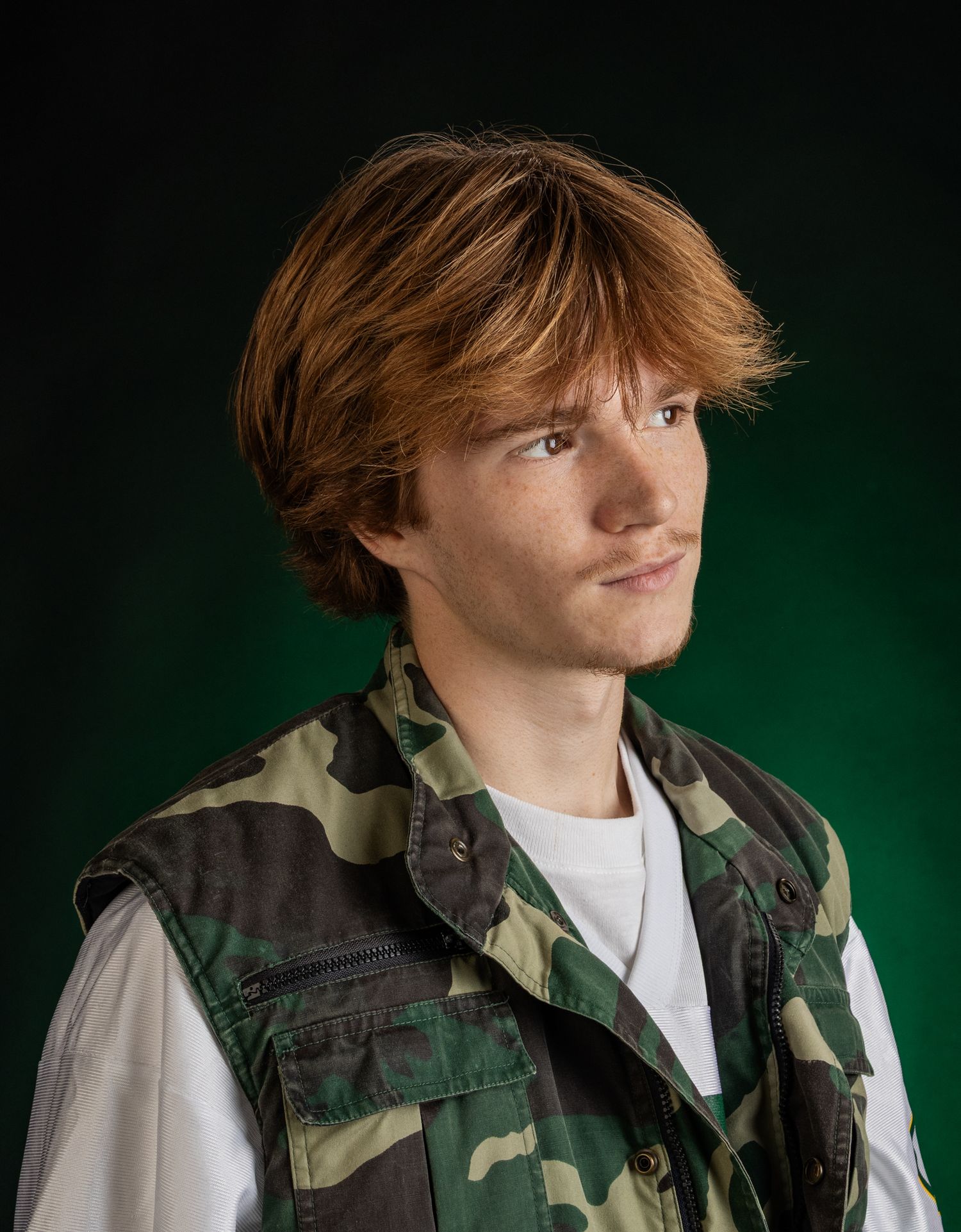 Male model headshot in front of green ombre background