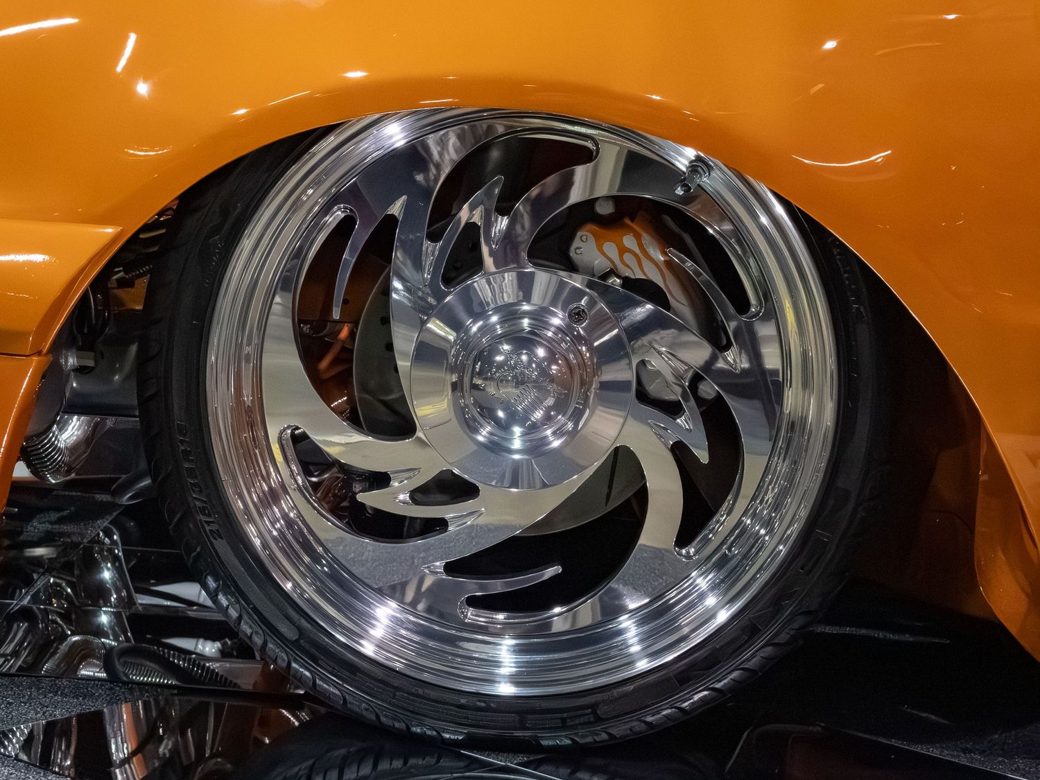 Close up orange car's silver chrome wheel