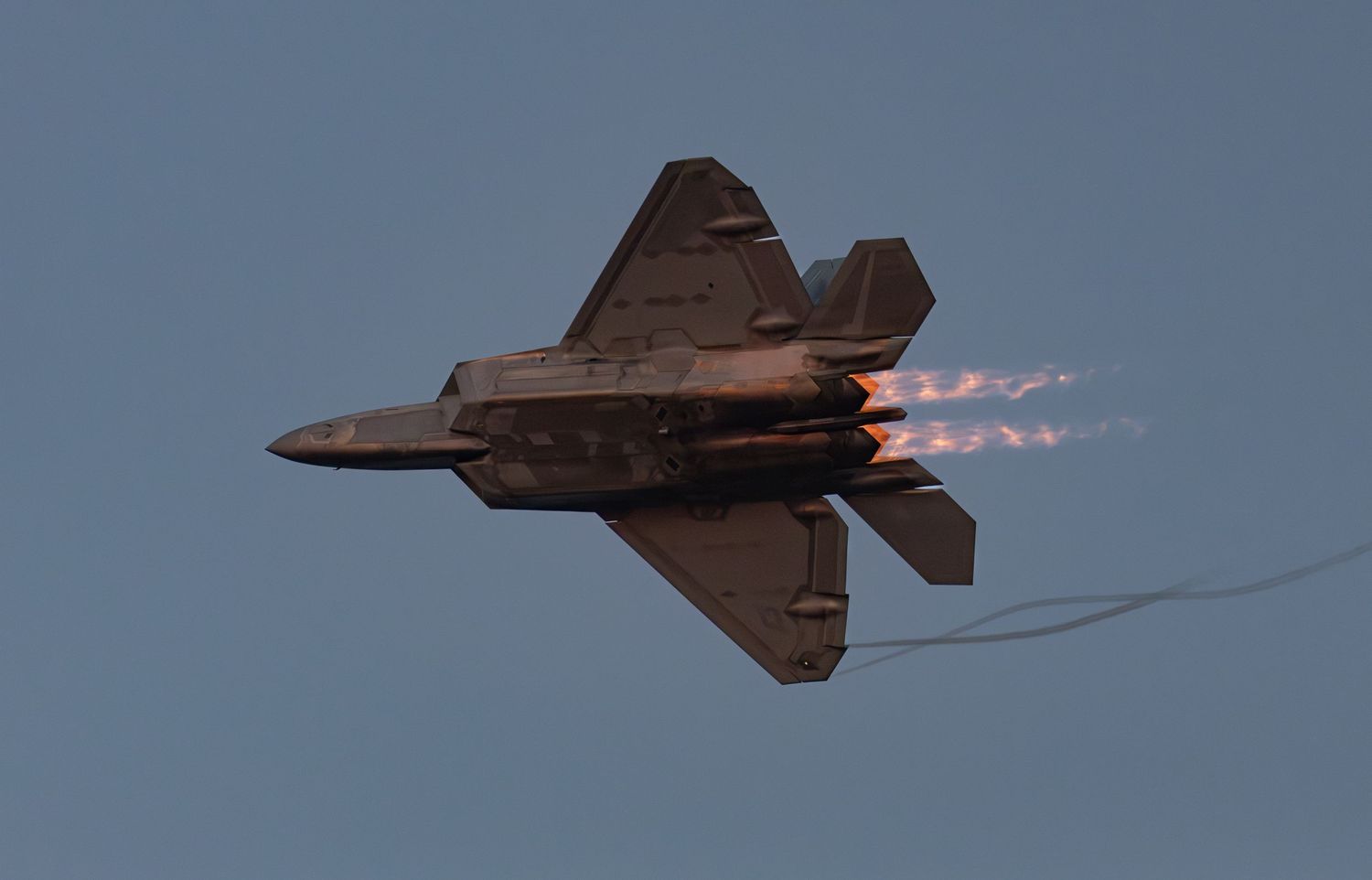 F-22 Raptor flying with afterburner in the evening