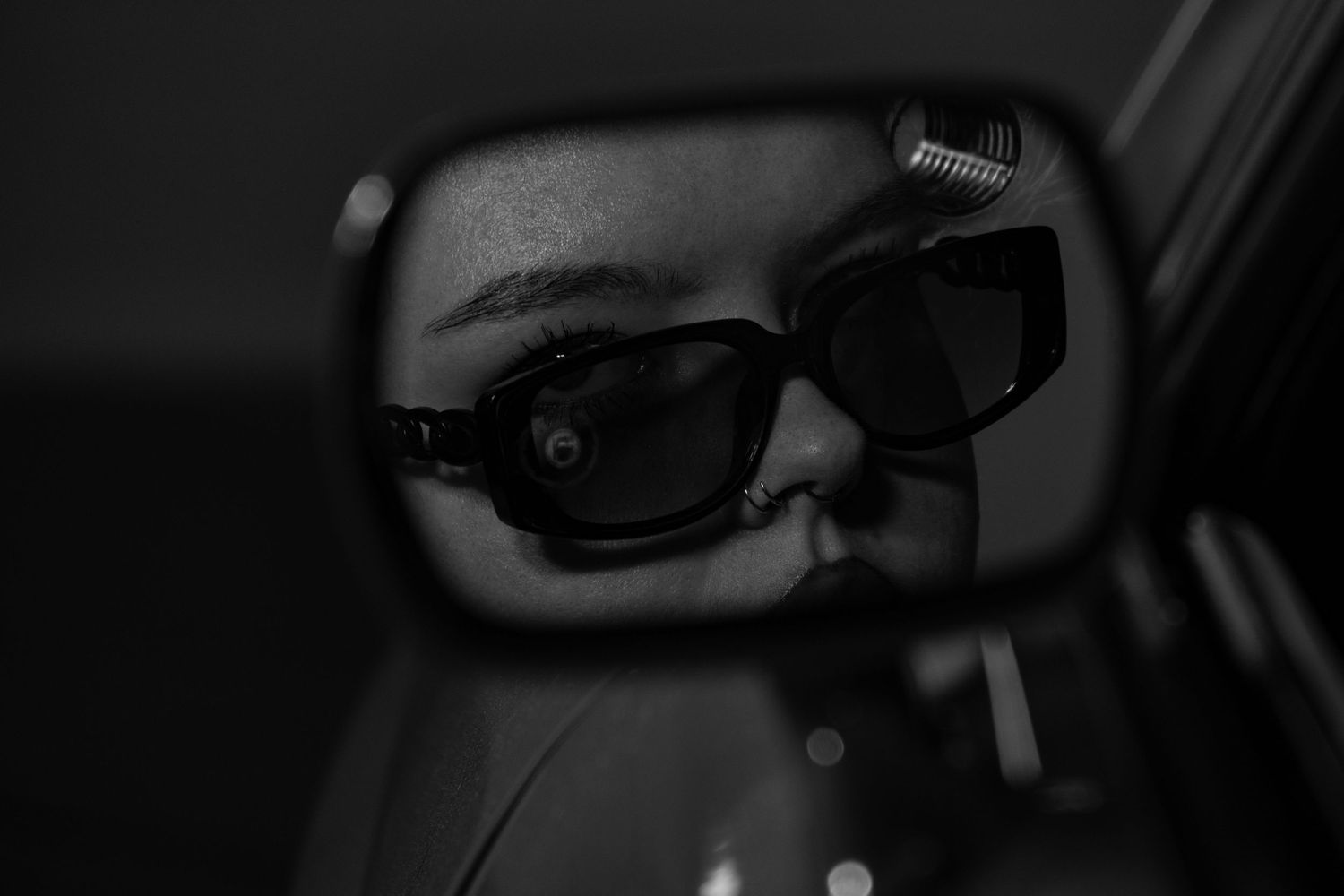 Female model portrait shot in side view mirror