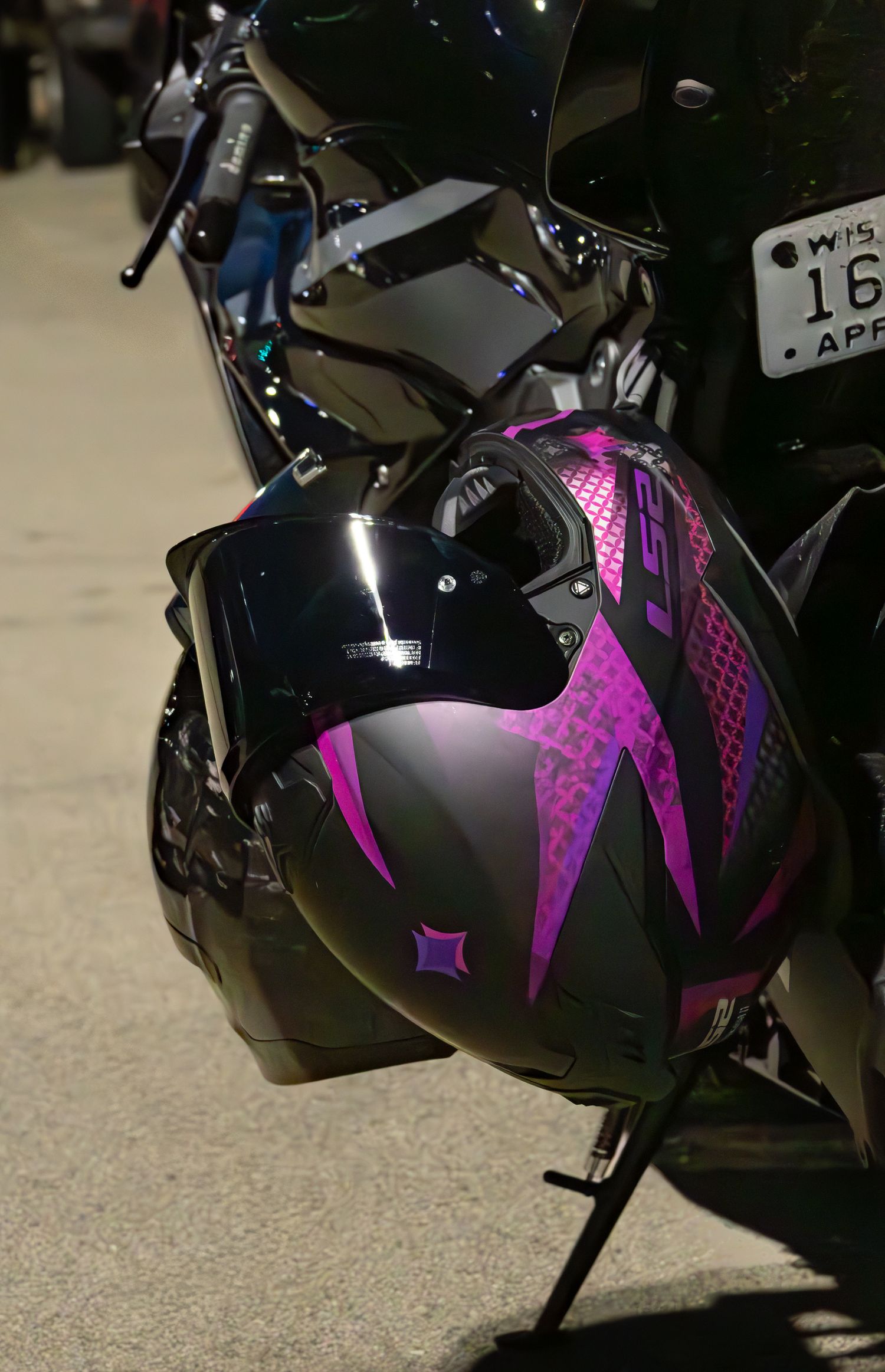 Purple motorcycle helmet hanging off of side of sport bike
