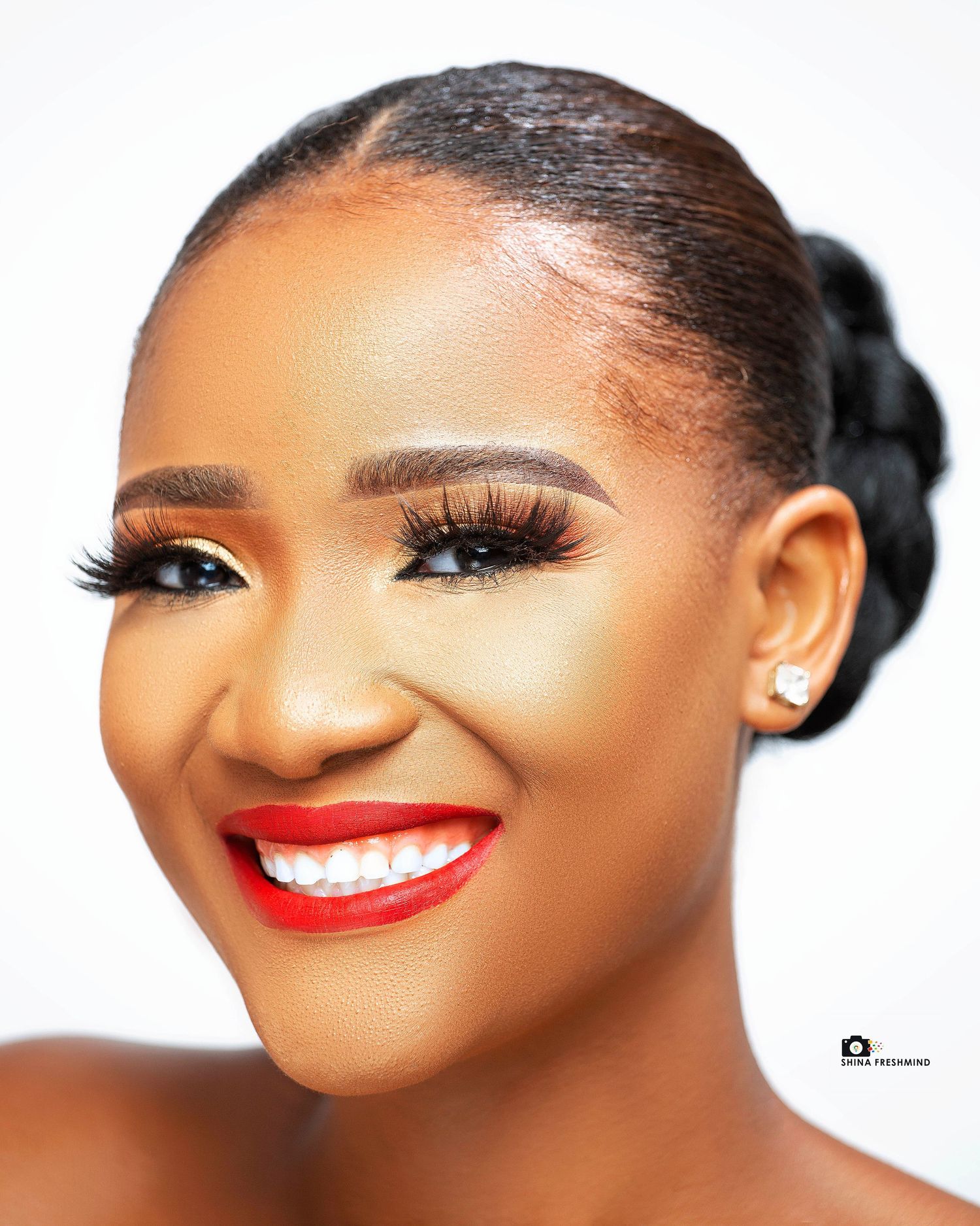 Beauty portrait showing glamorous makeup with red lipstick and sleek hairstyle.