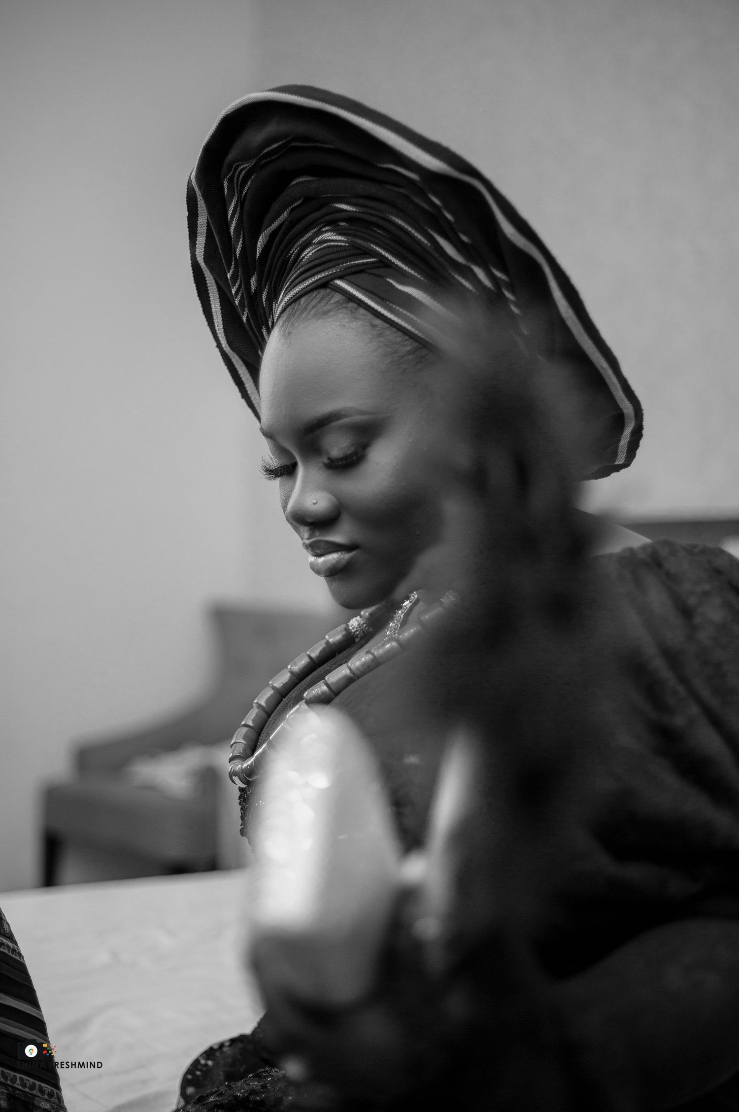 Artistic black and white portrait series with dramatic lighting and head wrap styling.