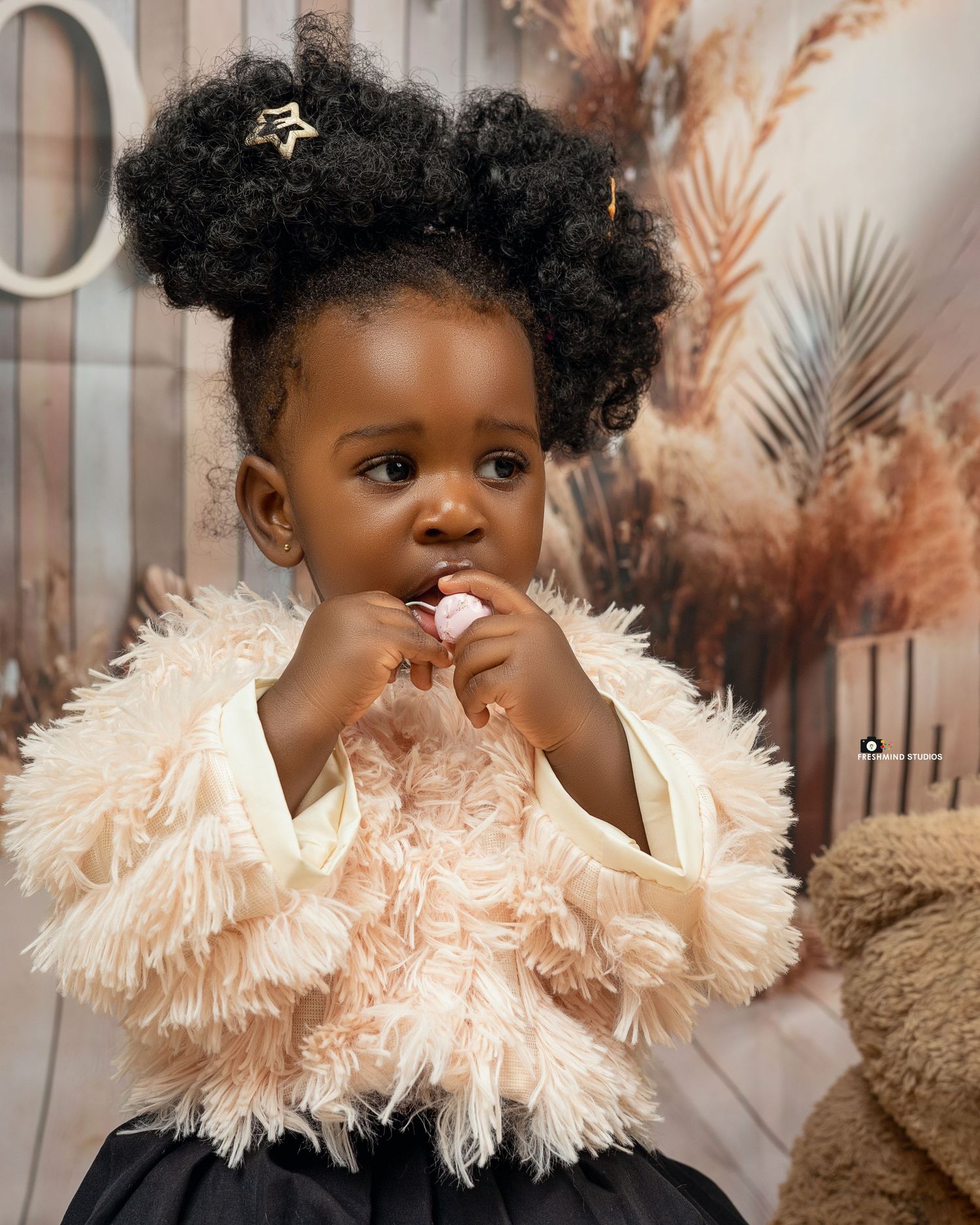 Child portrait series with fluffy cream collar against warm-toned pampas grass backdrop.