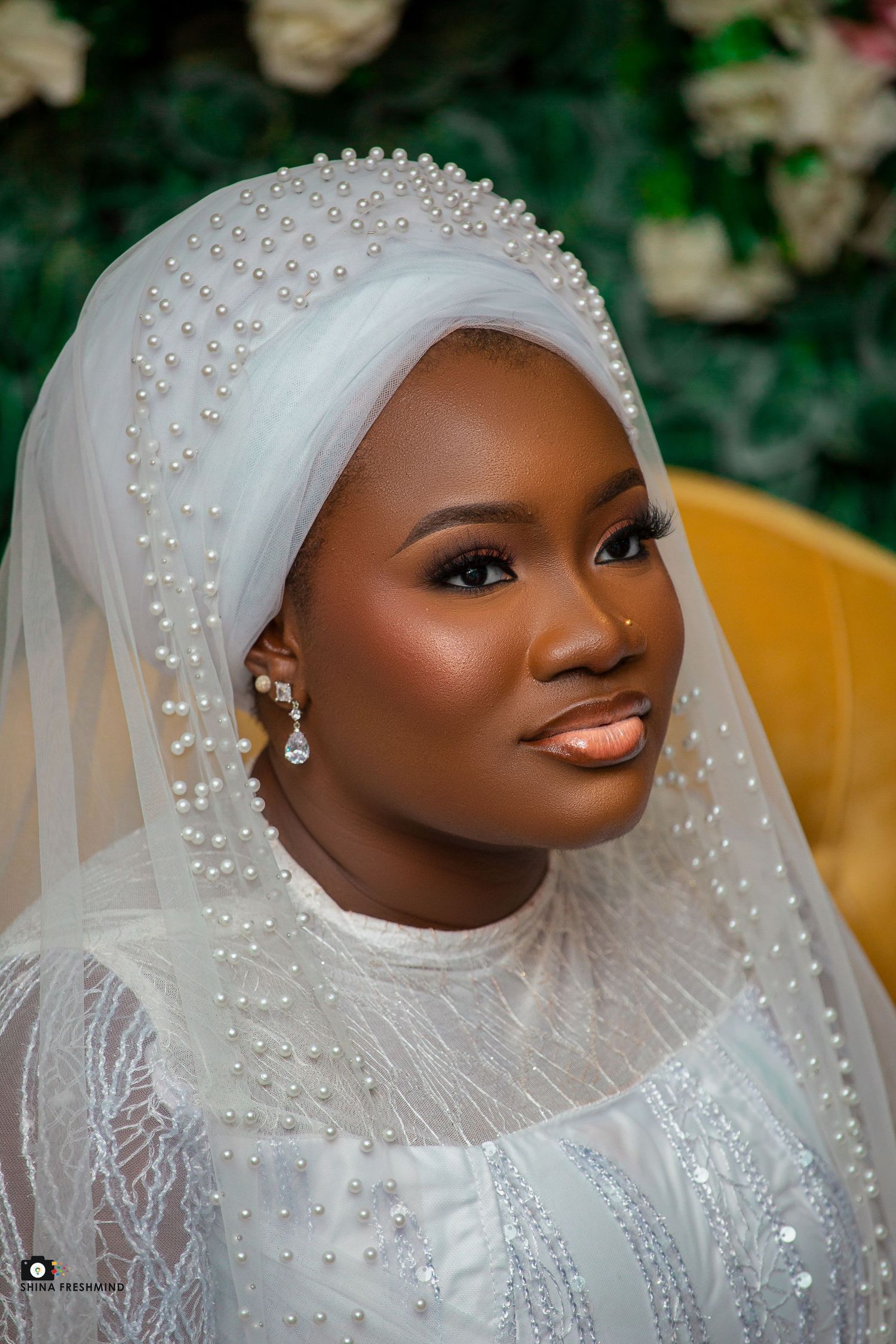 Bridal portrait featuring pearl-embellished veil and natural glowing makeup.