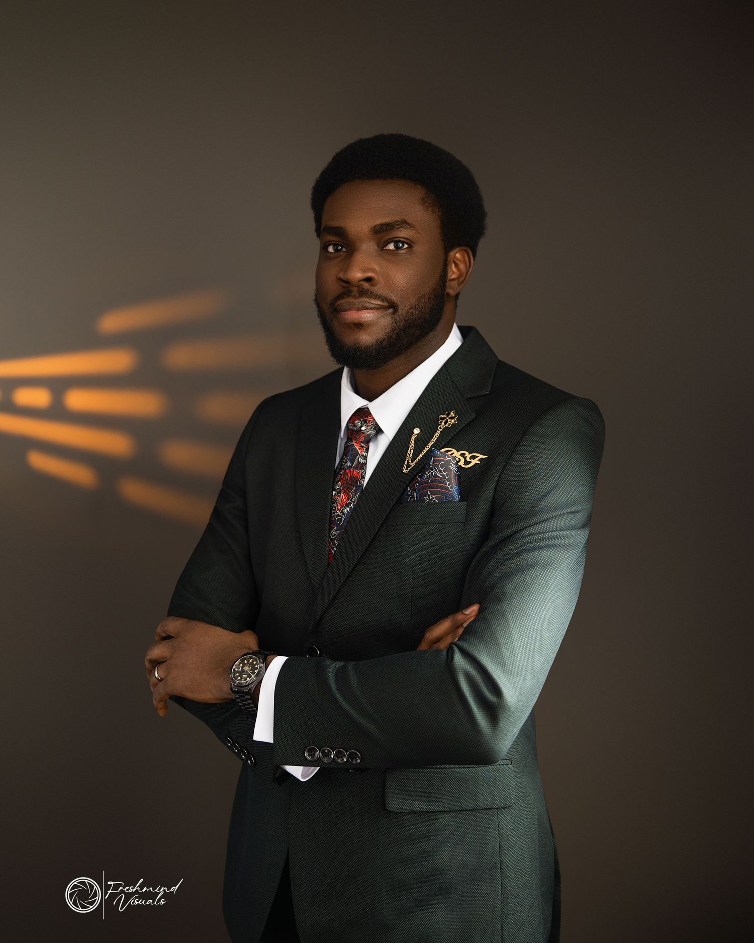 Professional studio portrait of someone in dark suit with orange lighting effects.