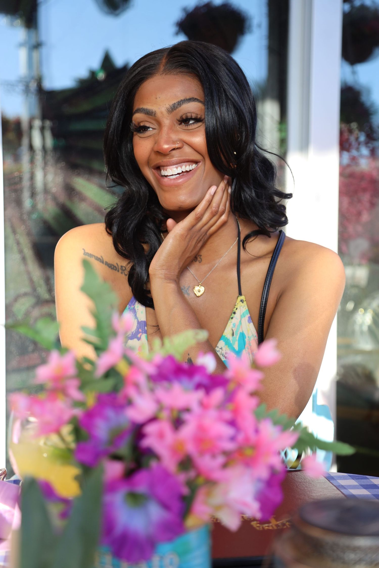 Portrait with vibrant pink and purple flowers in foreground creates joyful summer atmosphere.