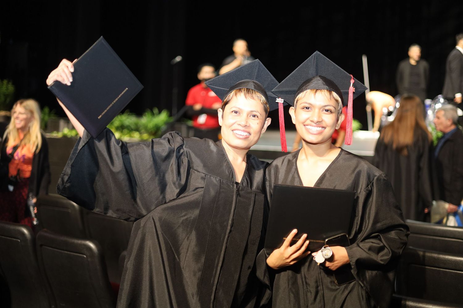 Graduates in black academic regalia pose together during ceremony.