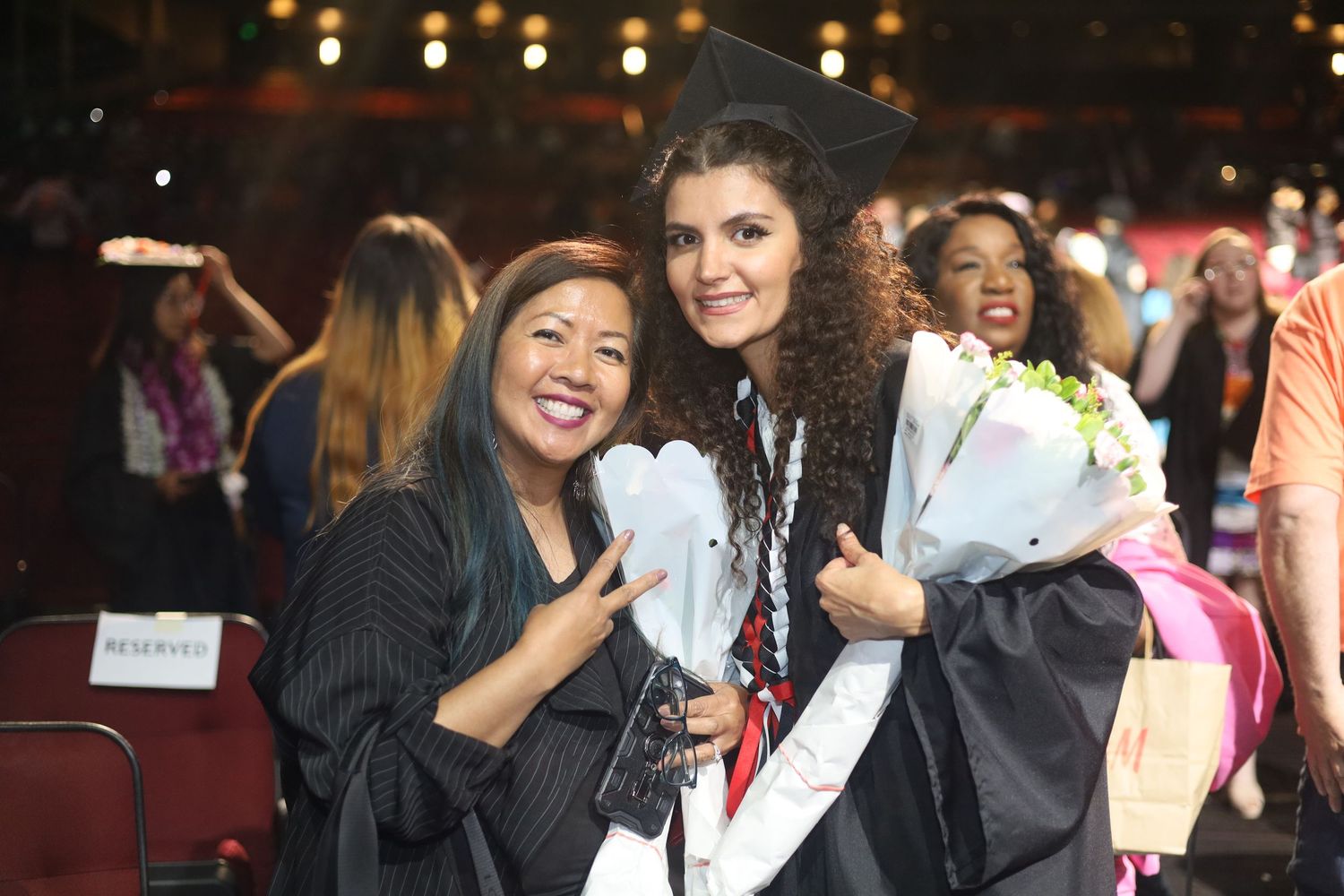 Happy graduates with decorated caps and stoles celebrate together.