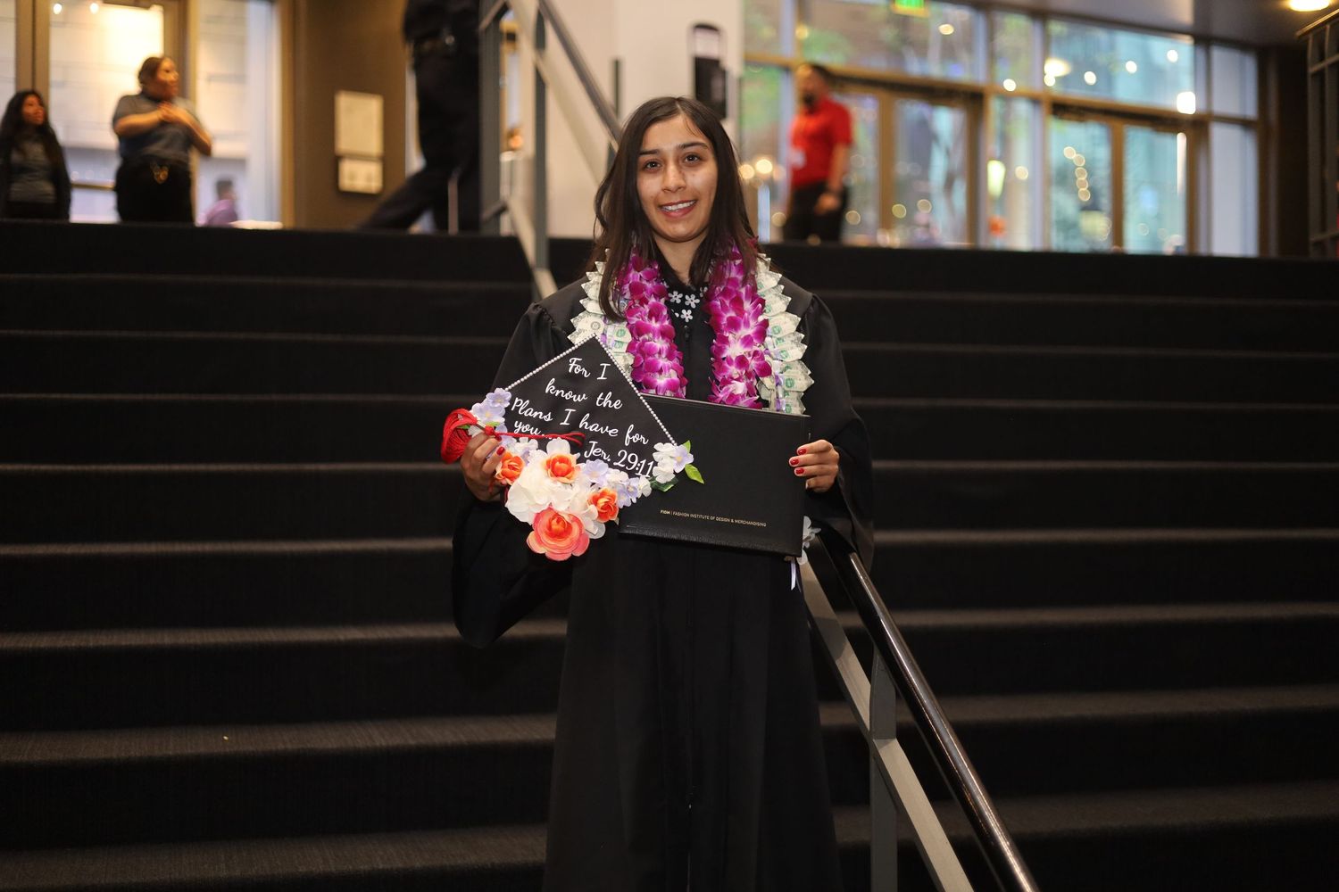 Graduates in black caps and gowns celebrate during commencement ceremony.
