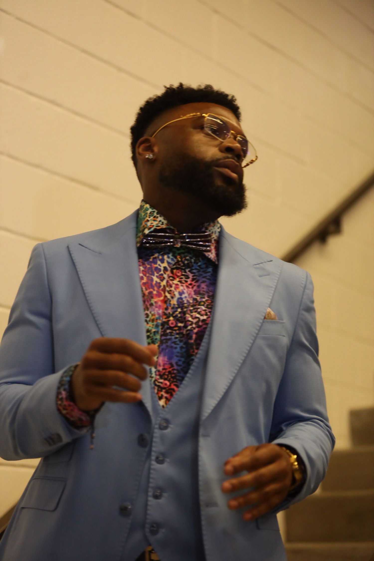 Stylish light blue three-piece suit with colorful patterned shirt shown in sequence of fashion poses.