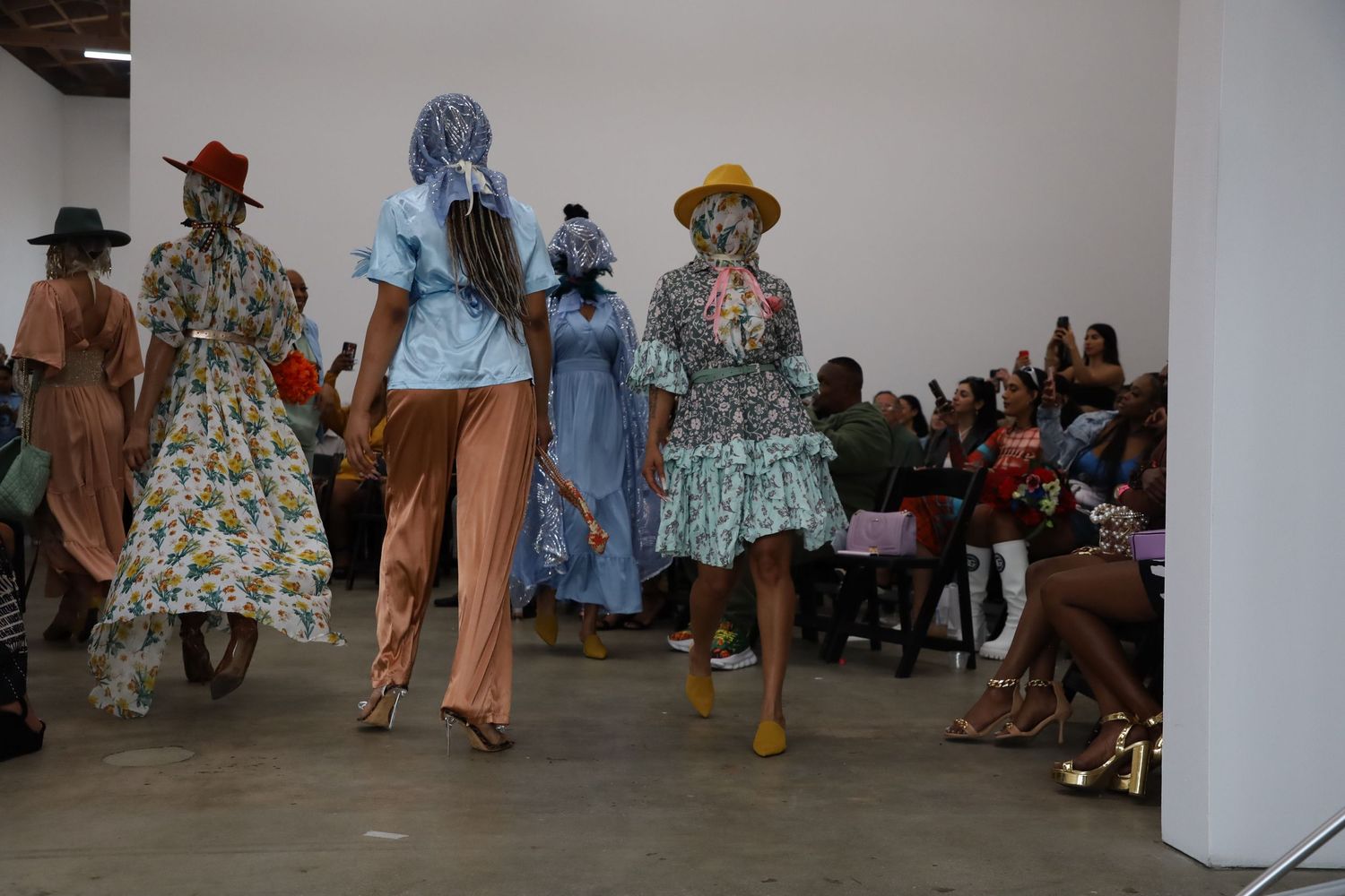 Models walk the runway in vintage-inspired dresses and separates at a fashion show.
