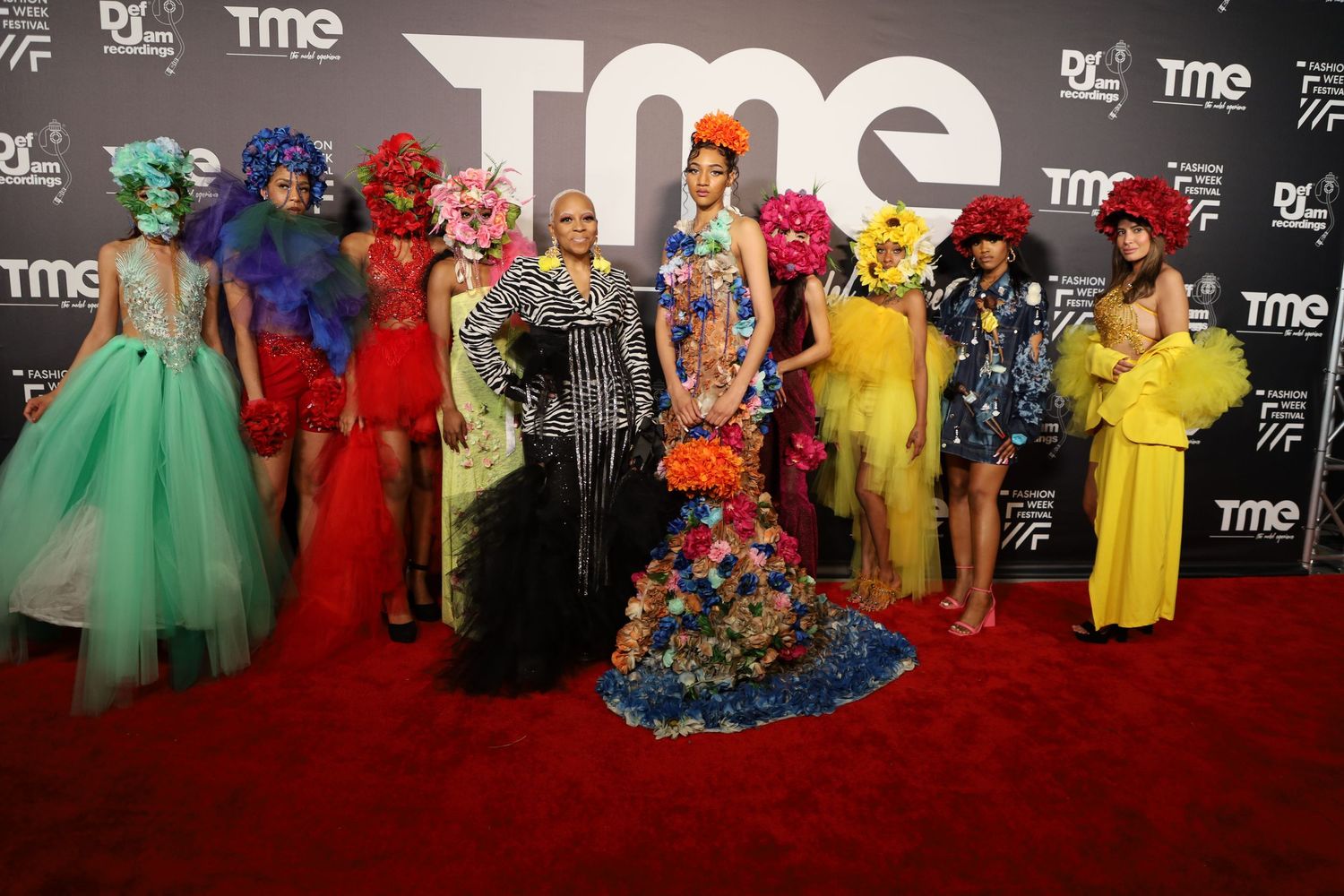 Group photo of colorfully dressed attendees at TME fashion event.