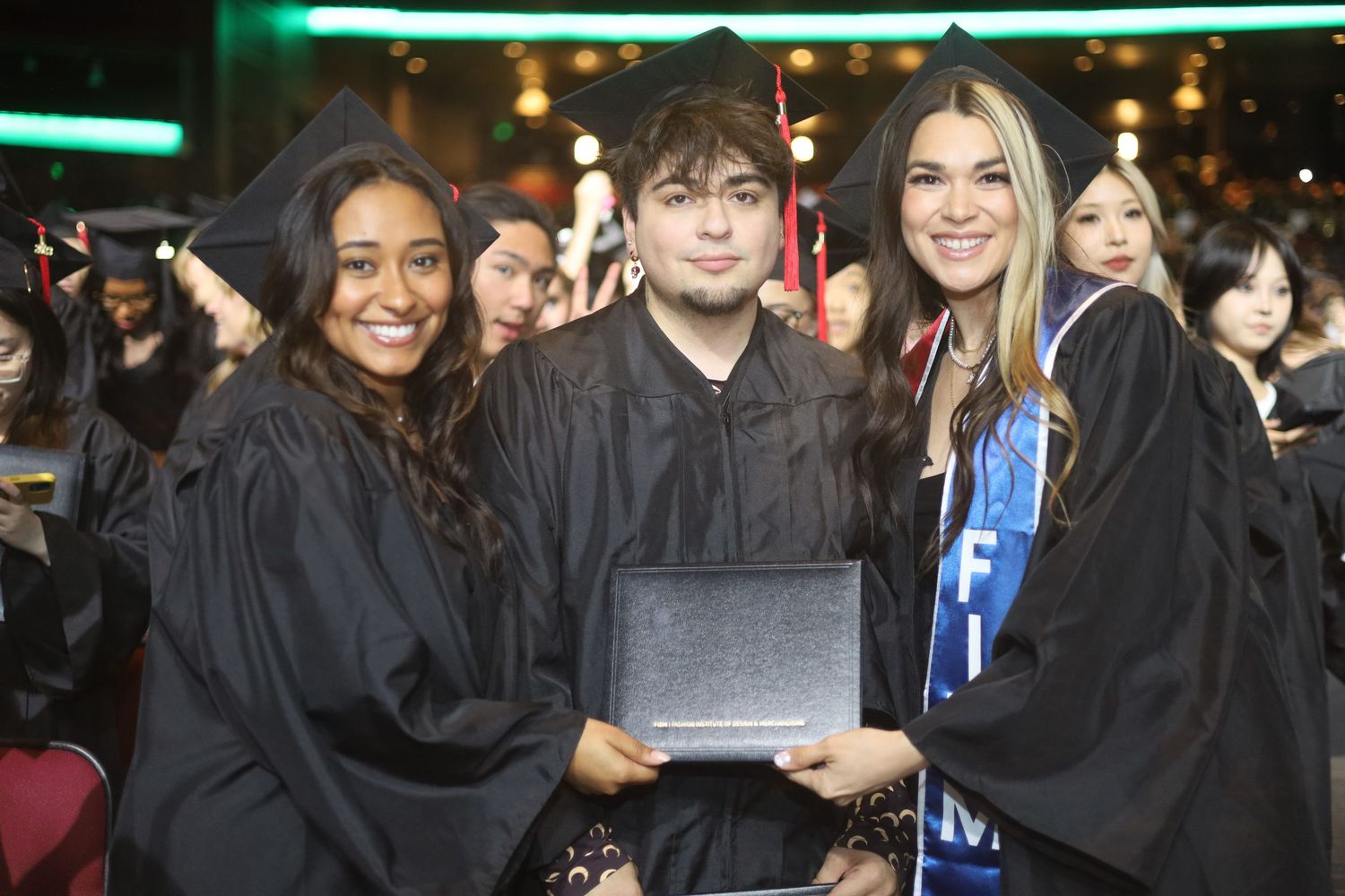 Graduates in black caps and gowns posing together for photos.