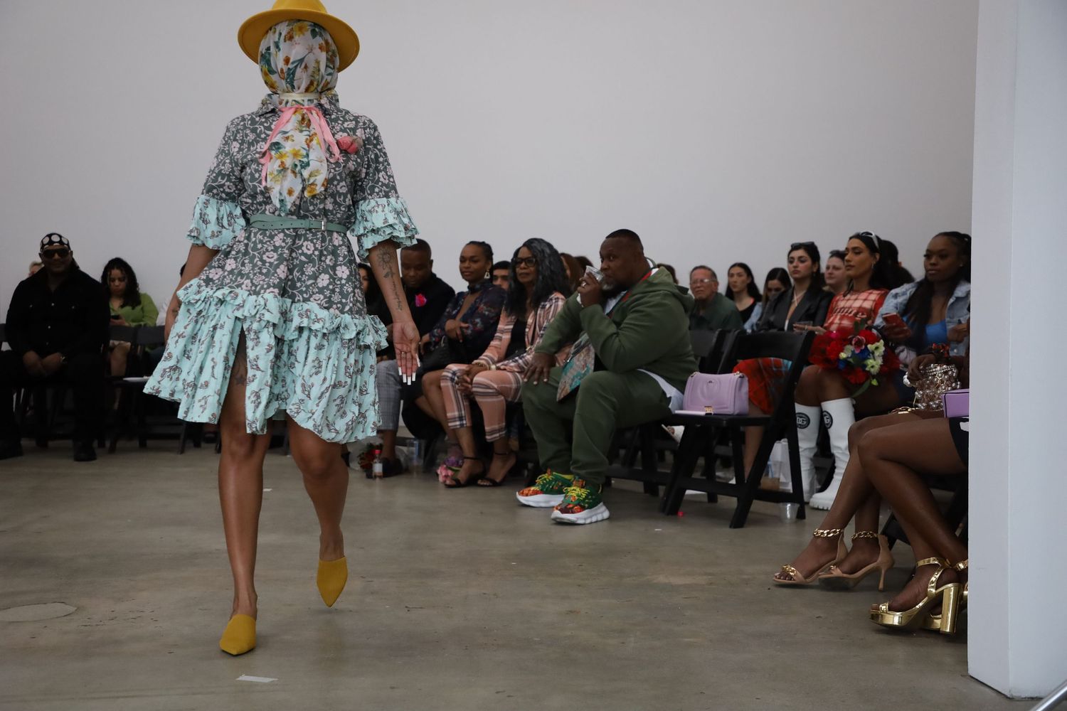 Runway show in progress with audience members viewing fashion presentations.