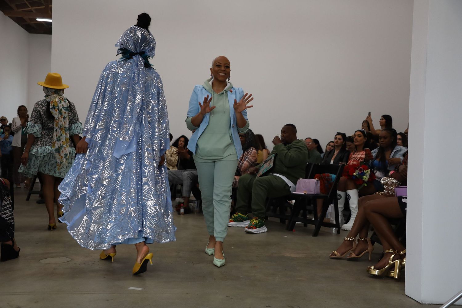 Models present flowing dresses and coordinated separates on a minimalist runway.