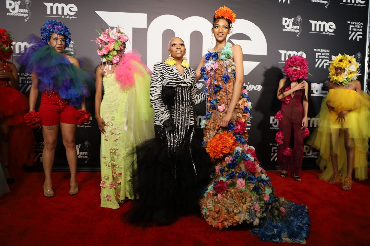 Red carpet photo showing attendees in bright formal attire at TME branded event.