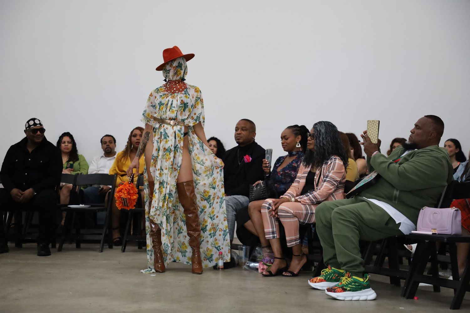 Models present colorful spring fashion collection with dramatic poses on indoor runway.
