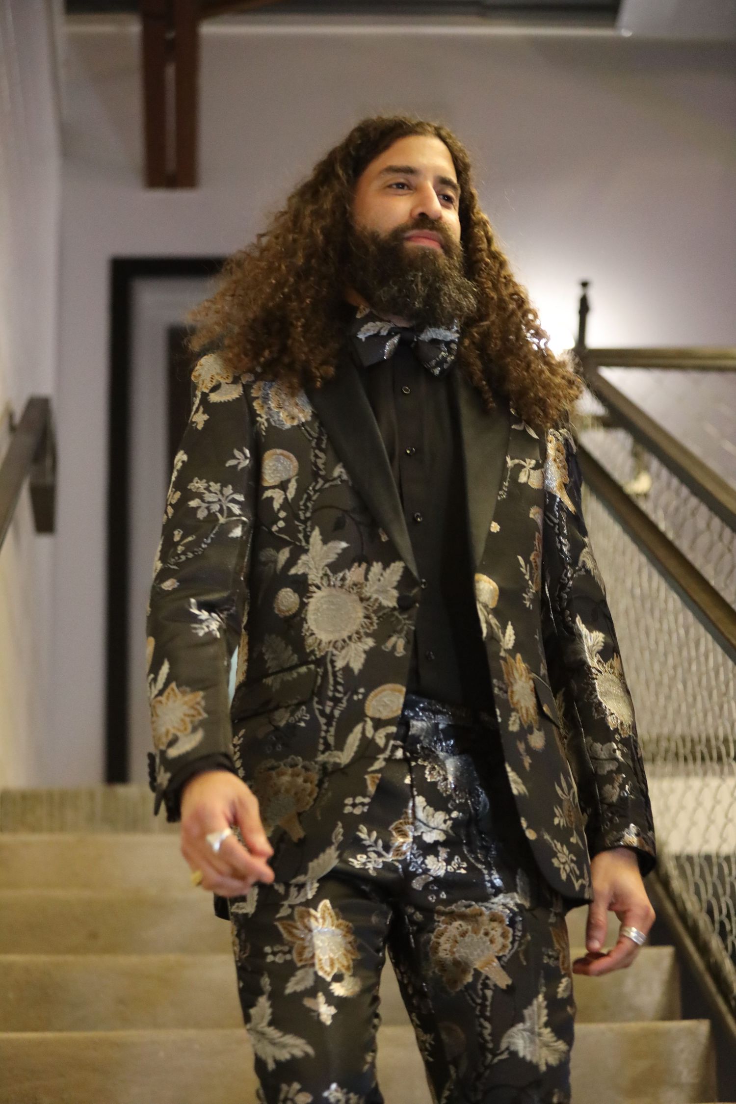 Dark floral print blazer with metallic details photographed on staircase.