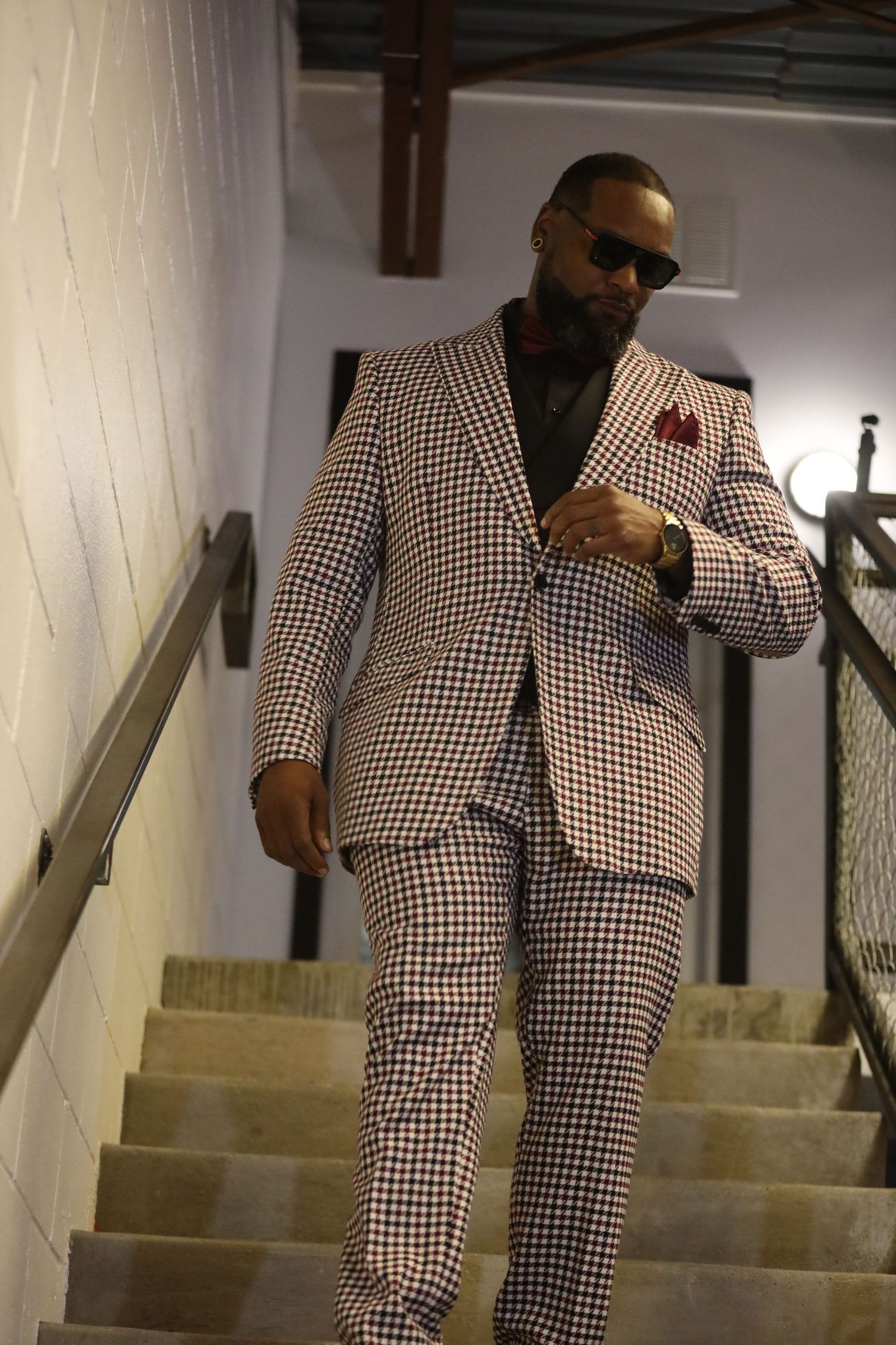 Gingham pattern suit showcased on stairs with dramatic lighting and angles.