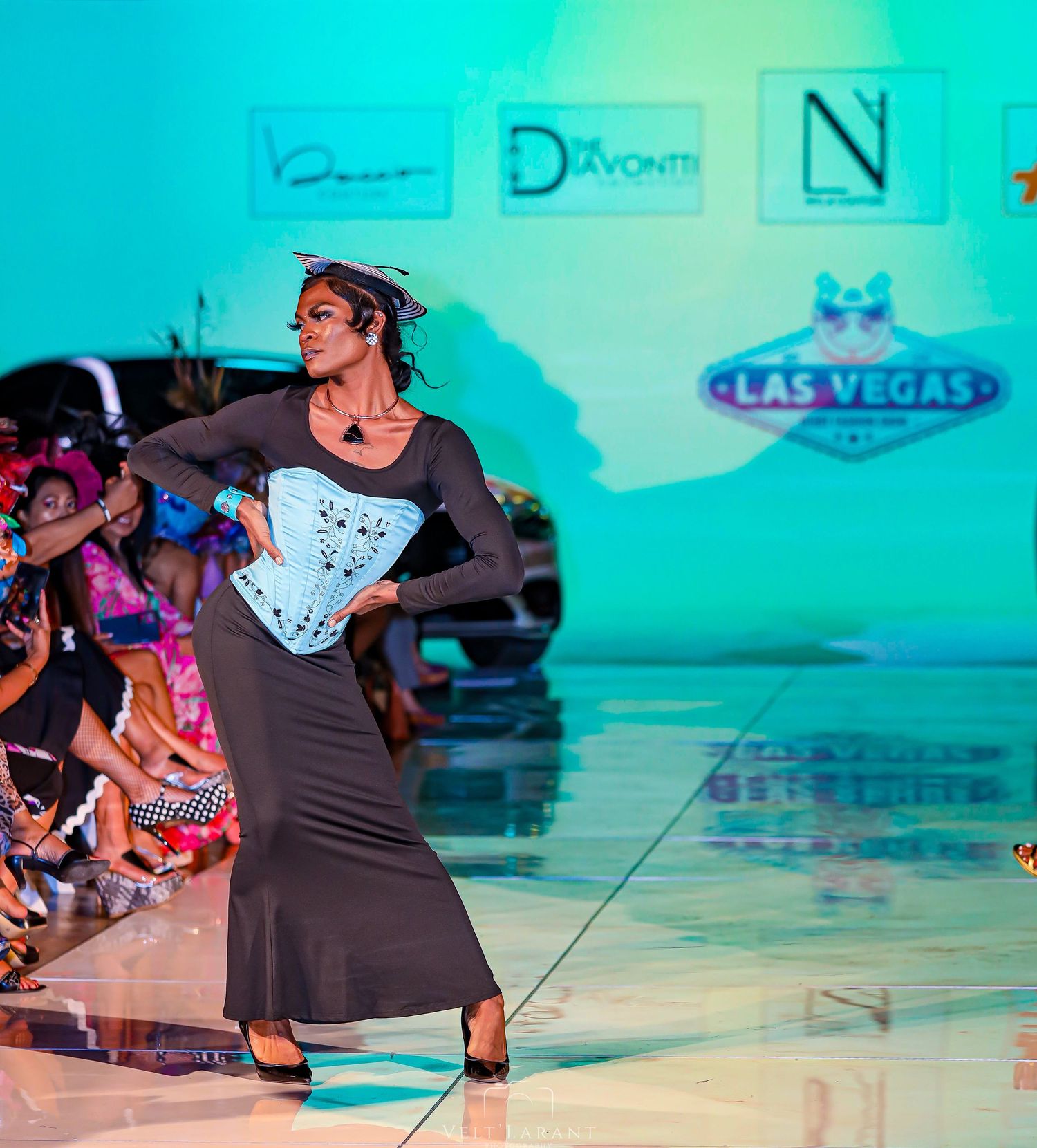 Model walks runway in black and white corset dress during Las Vegas fashion show.